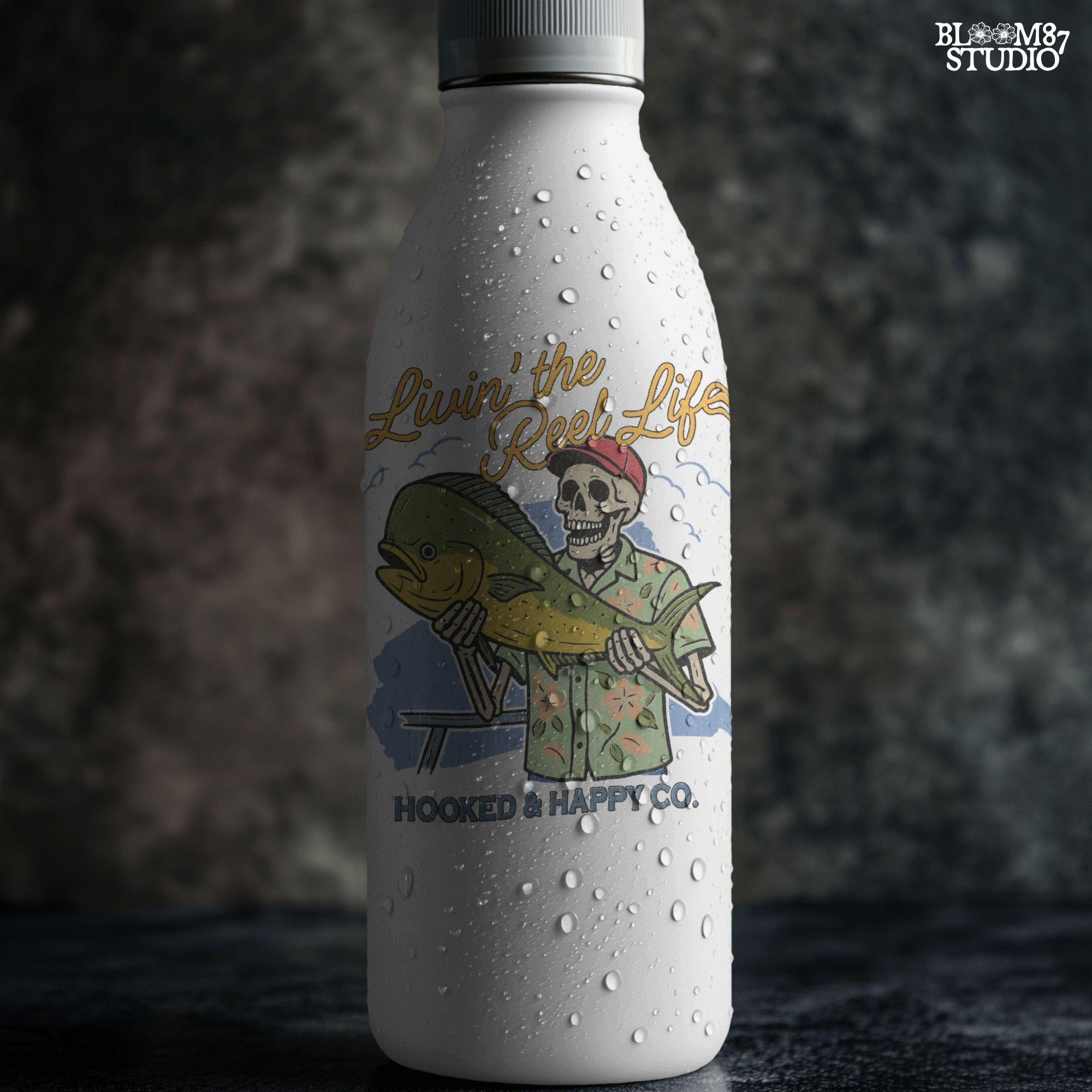 Cartoon skeleton in tropical shirt holding a mahi-mahi fish with text “Livin’ the Reel Life” above and “Hooked & Happy Co.” below.