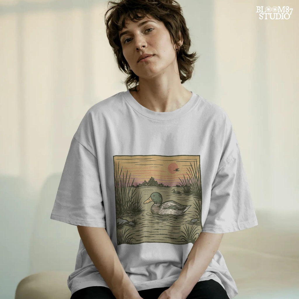 Illustration of a mallard duck swimming in a quiet pond at sunset, surrounded by reeds and a peaceful landscape in warm fall tones.