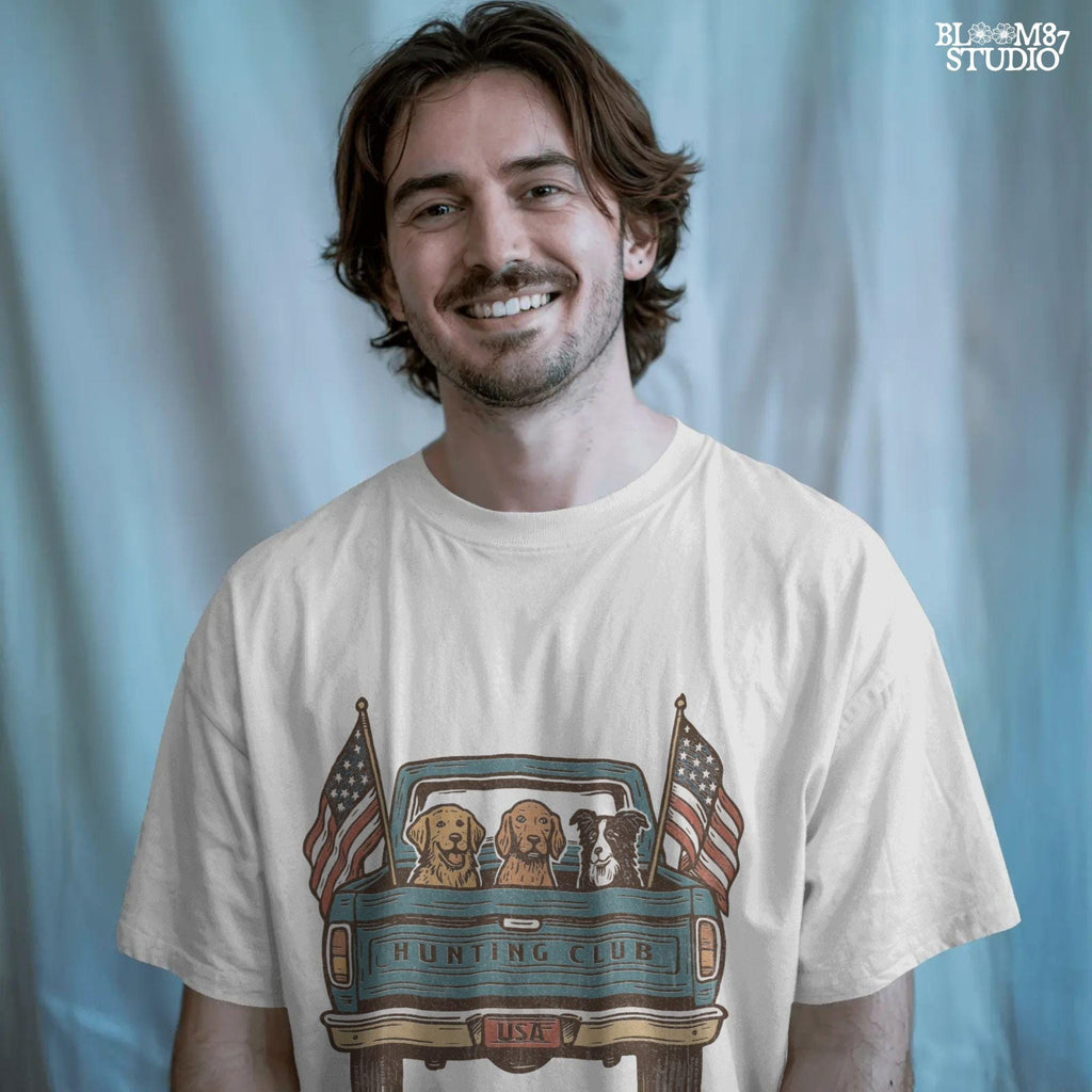 Three hunting dogs in the back of a blue vintage pickup truck with USA flags and “Hunting Club” text, patriotic hunting design for dog lovers.