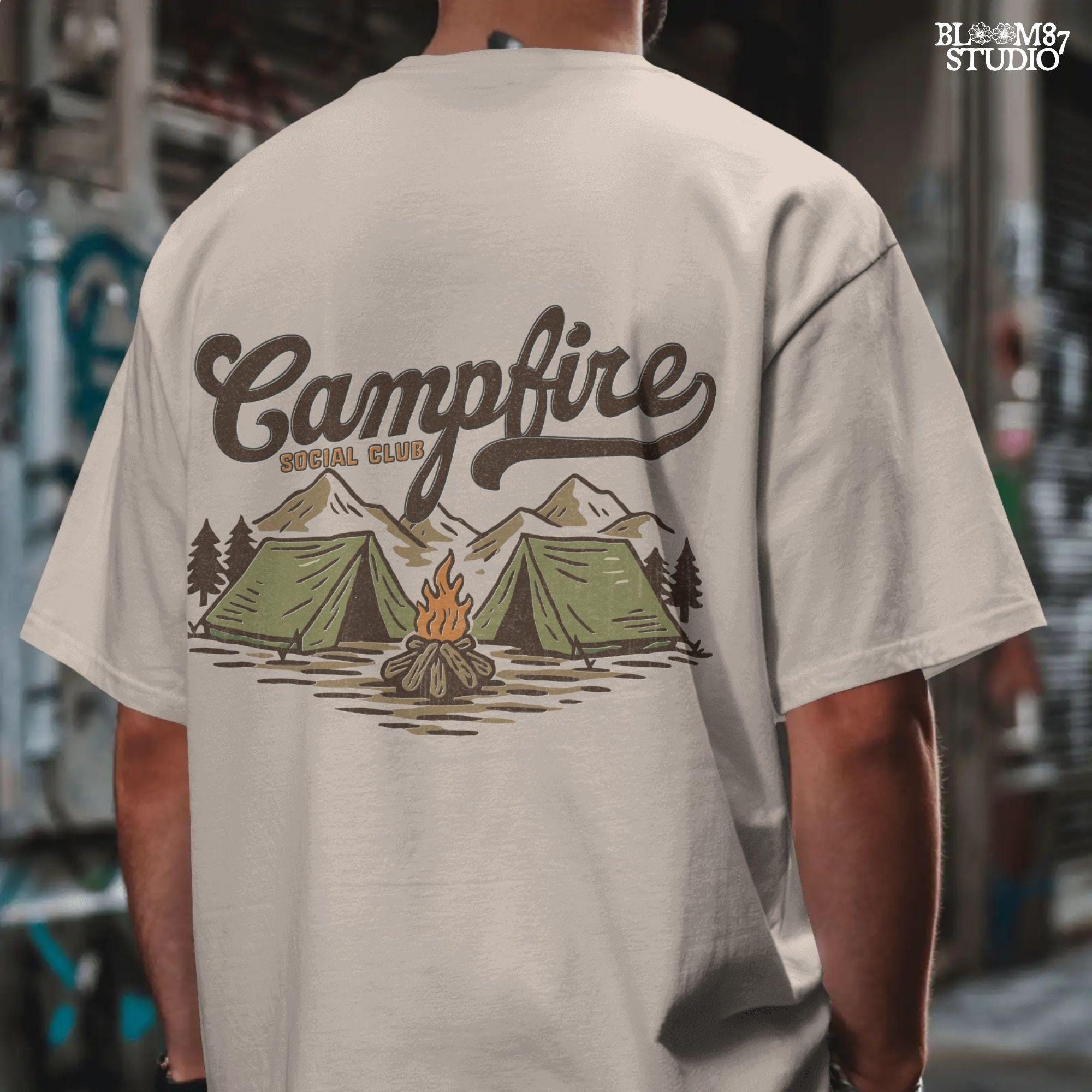 Vintage-style illustration of two camping tents, a lit campfire, pine trees, and mountains with the text “Campfire Social Club.”