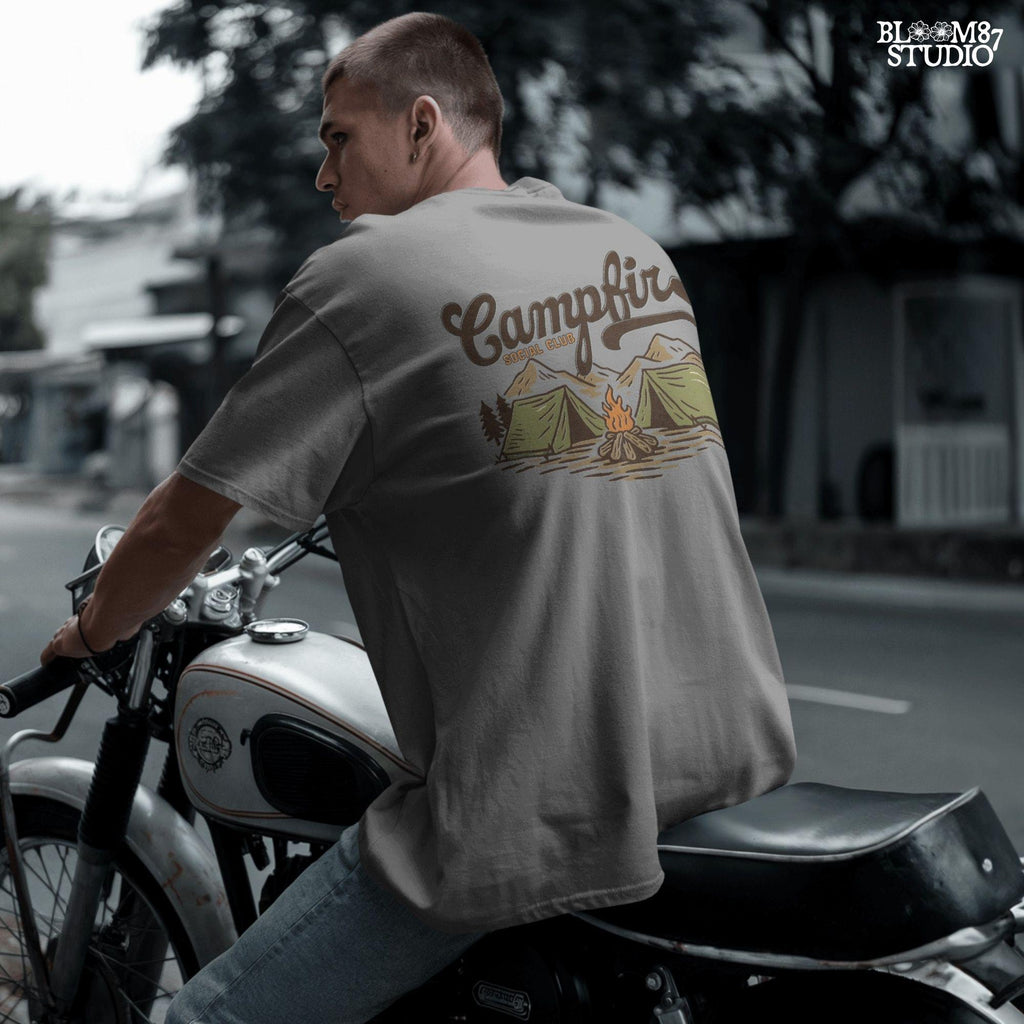 Vintage-style illustration of two camping tents, a lit campfire, pine trees, and mountains with the text “Campfire Social Club.”