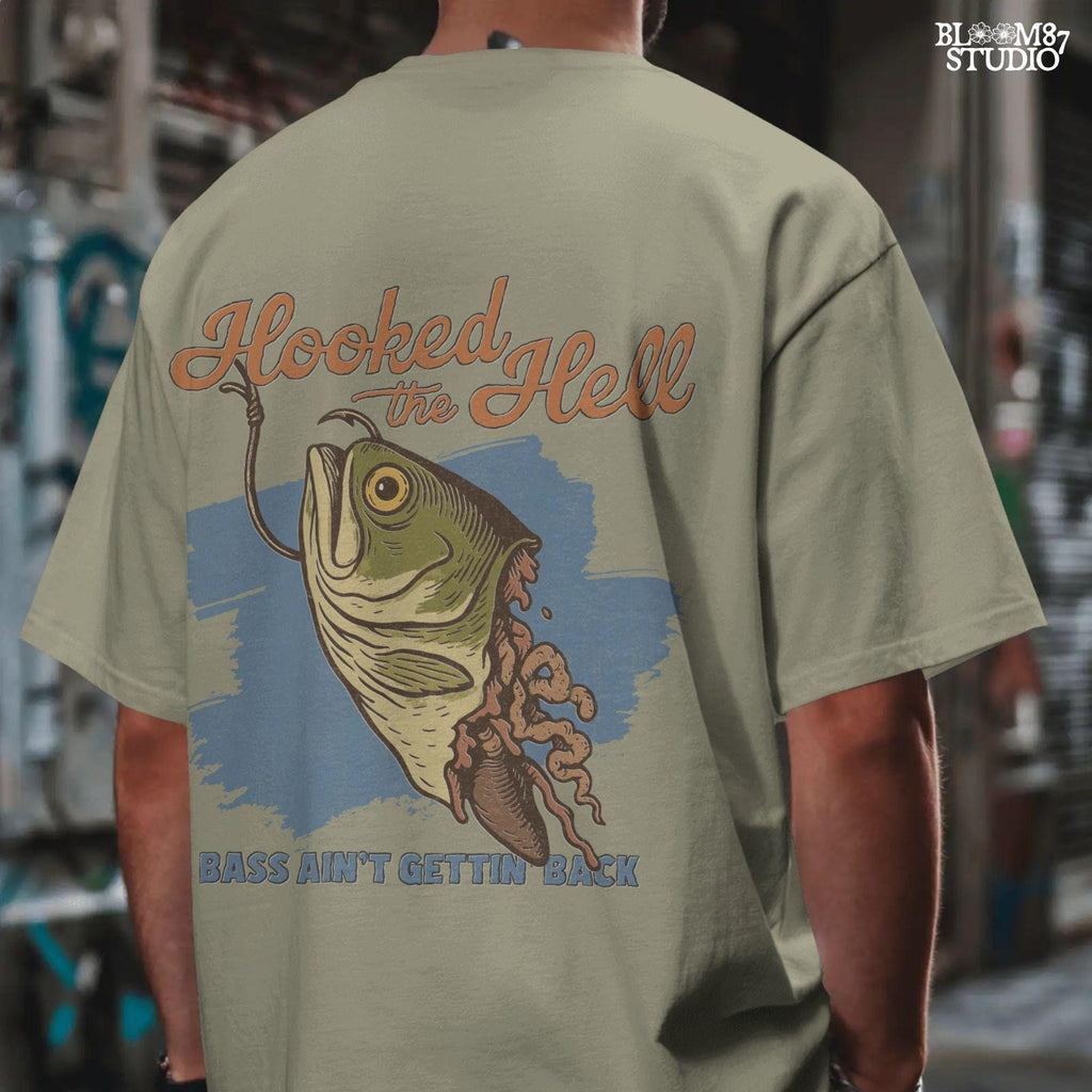 Funny exaggerated bass fish graphic with a hook through its mouth and dramatic detailing, paired with the text “Hooked the Hell” and “Bass Ain’t Gettin Back.”