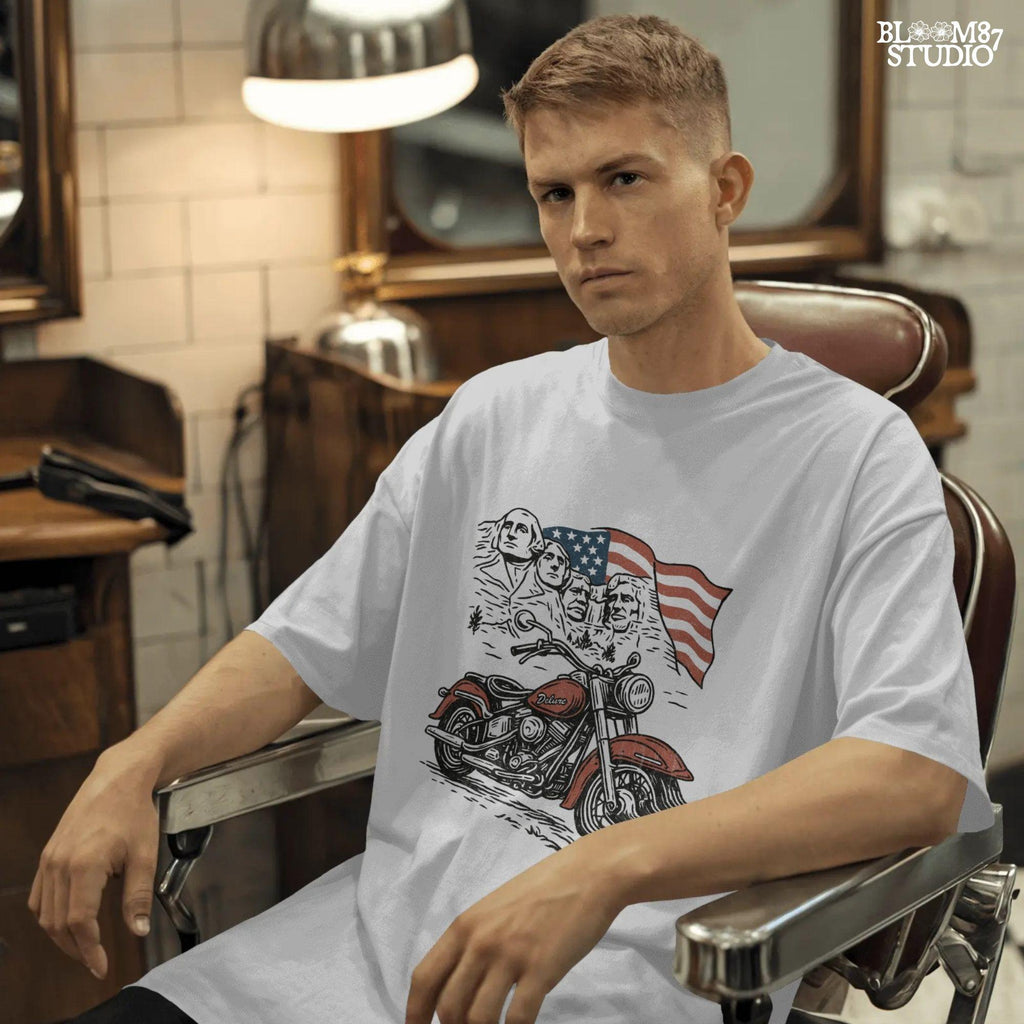 Vintage motorcycle graphic in front of Mount Rushmore and a waving American flag, styled in patriotic colors with retro biker design elements.