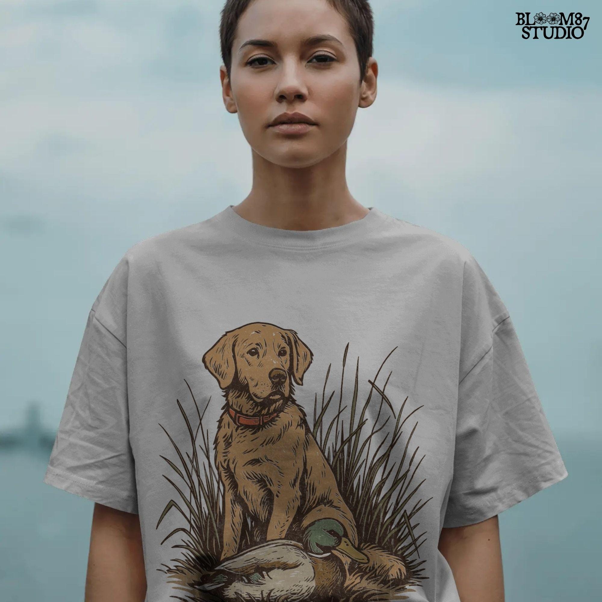 Vintage illustration of a golden Labrador Retriever sitting in grass beside a mallard duck – rustic hunting dog PNG for sublimation and crafts.