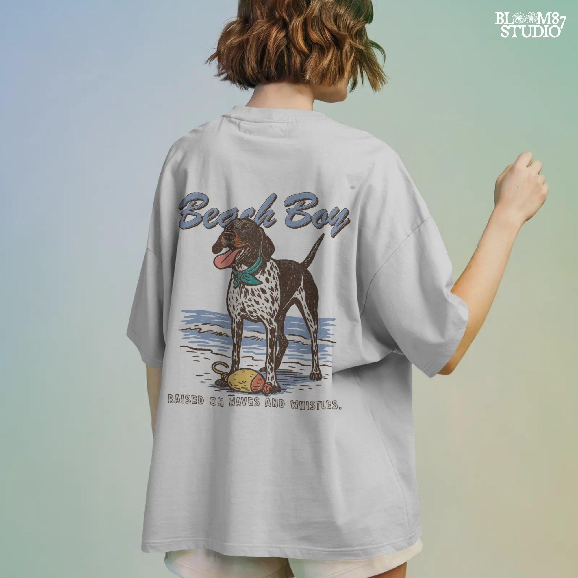 Vintage-style German Shorthaired Pointer standing on the beach with a buoy toy, text reads “Beach Boy – Raised on Waves and Whistles” – summer dog PNG.