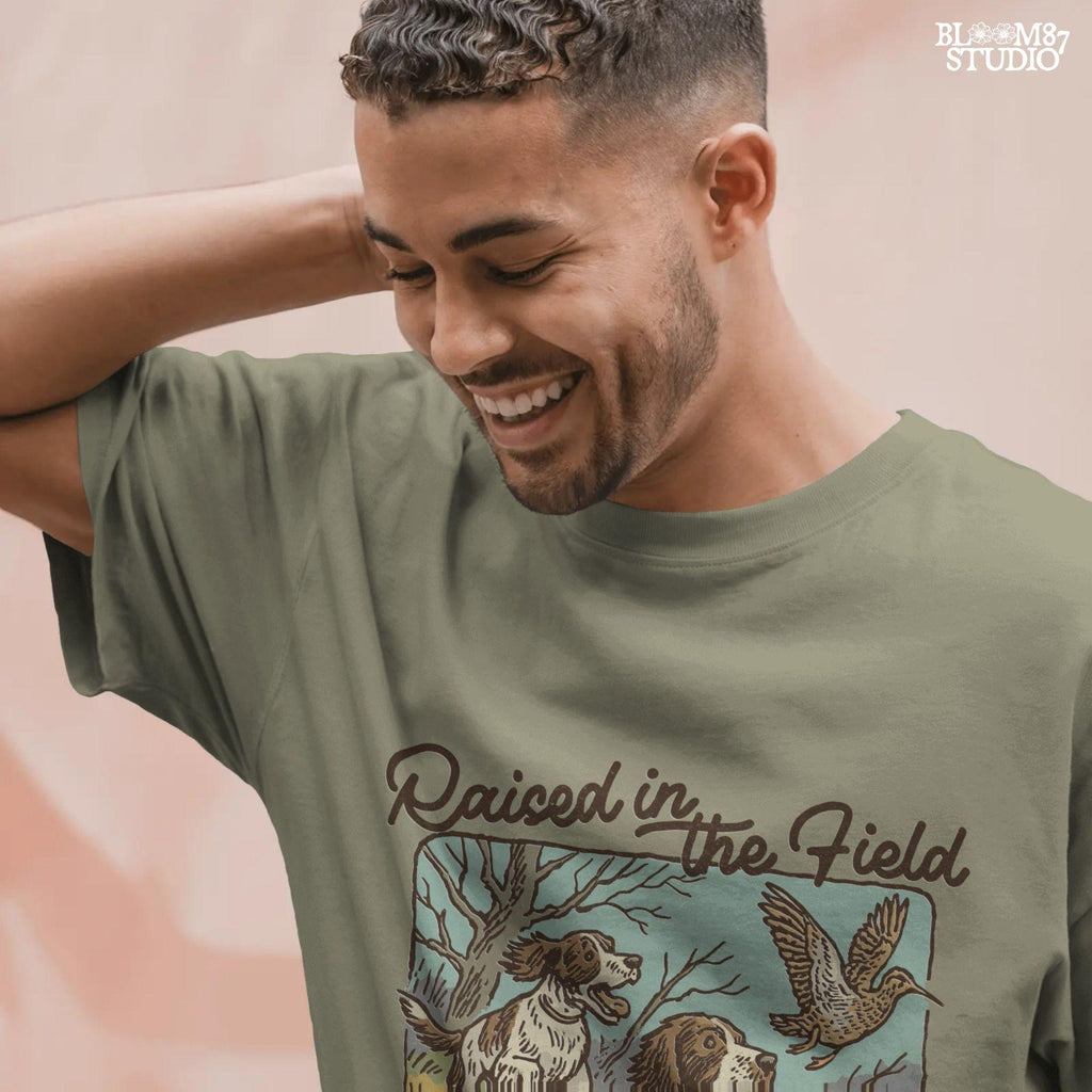 Rustic illustration of two Springer Spaniels flushing a game bird with the phrase “Raised in the Field” in vintage script.