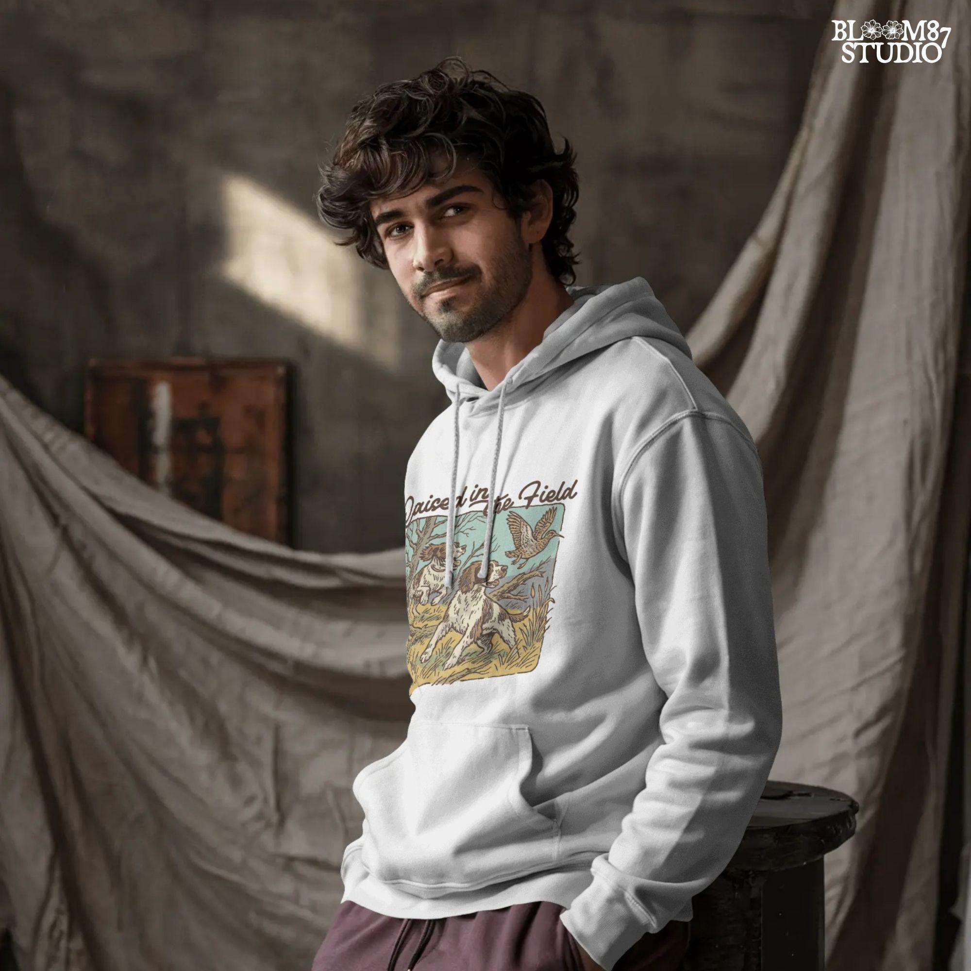 Rustic illustration of two Springer Spaniels flushing a game bird with the phrase “Raised in the Field” in vintage script.