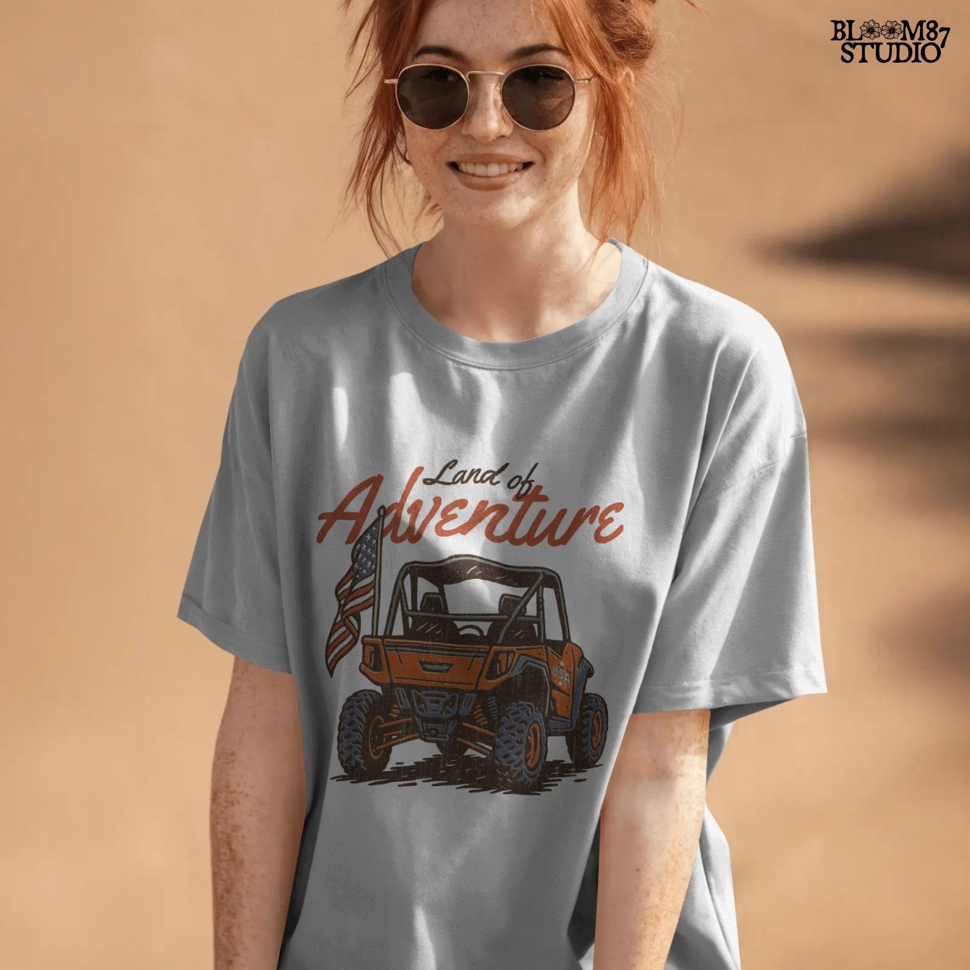 Off-road UTV with American flag driving on a dirt trail, text reads “Land of Adventure” – patriotic outdoor sublimation PNG design.