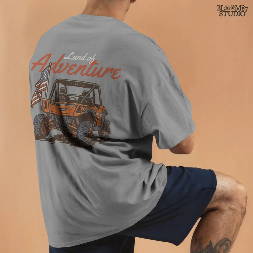 Off-road UTV with American flag driving on a dirt trail, text reads “Land of Adventure” – patriotic outdoor sublimation PNG design.