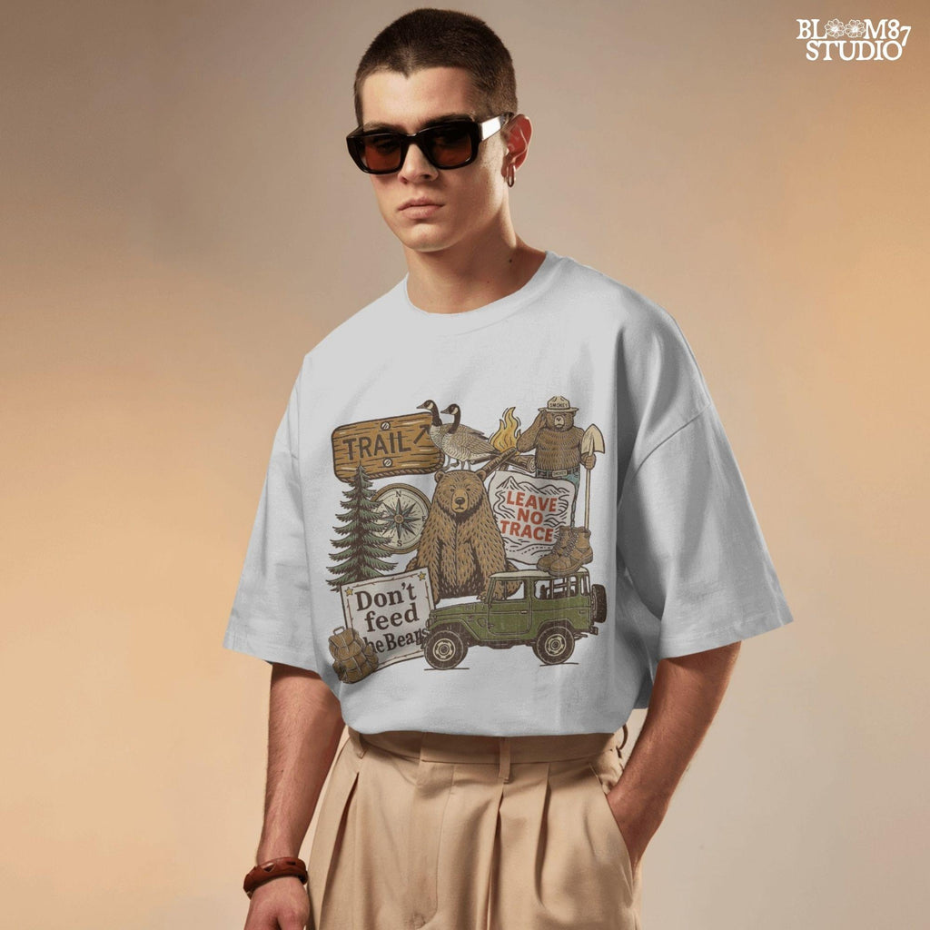 Illustration of a camping-themed collage featuring a grizzly bear, “Leave No Trace” sign, Smokey the Bear, trail sign, compass, boots, a green jeep, and forest scenery.