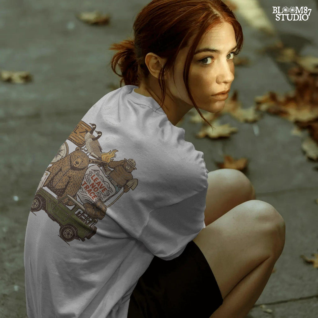 Illustration of a camping-themed collage featuring a grizzly bear, “Leave No Trace” sign, Smokey the Bear, trail sign, compass, boots, a green jeep, and forest scenery.