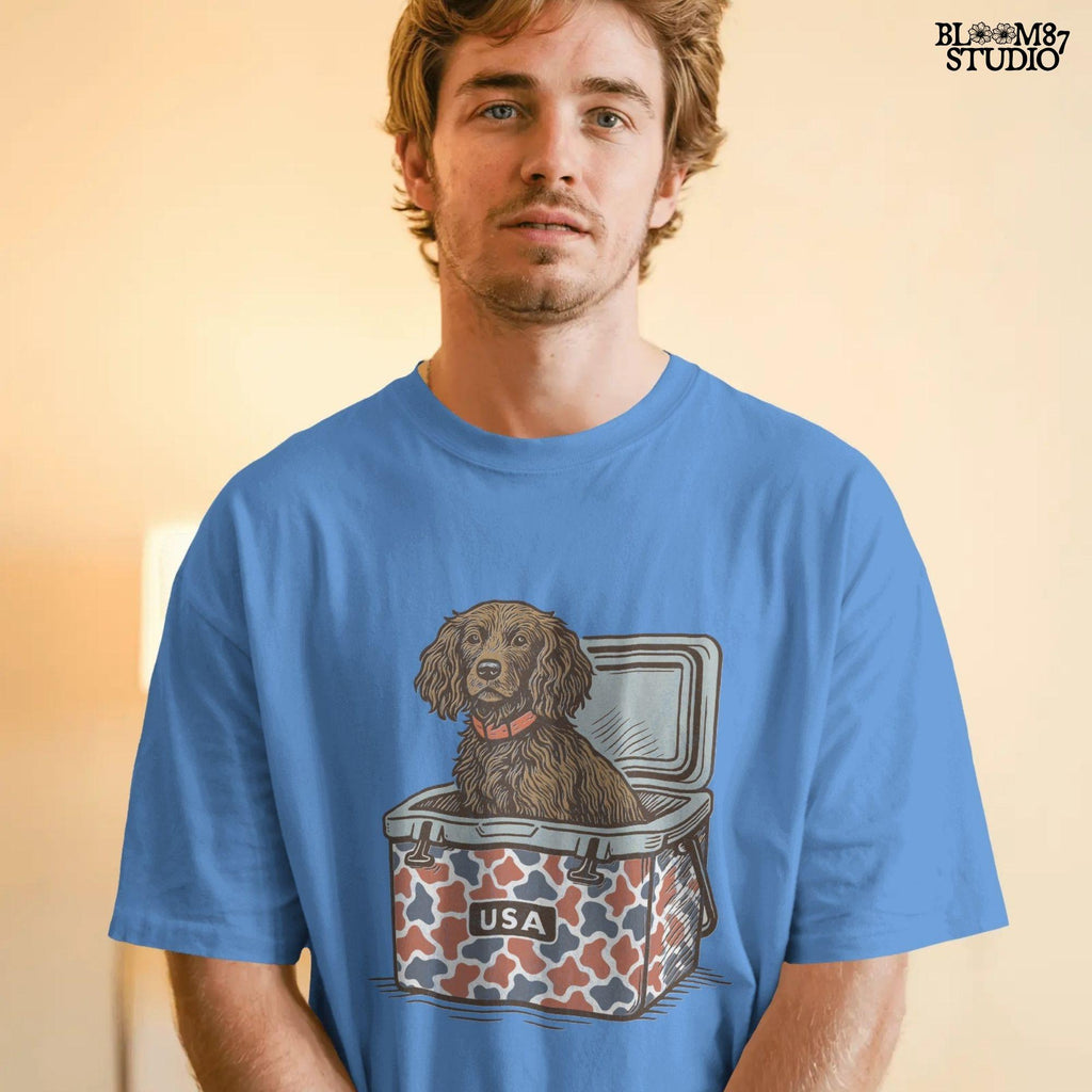 Sporting dog (spaniel type) sitting in a patriotic red-white-blue camo cooler labeled “USA” – sublimation PNG for southern dog lovers and summer crafts.