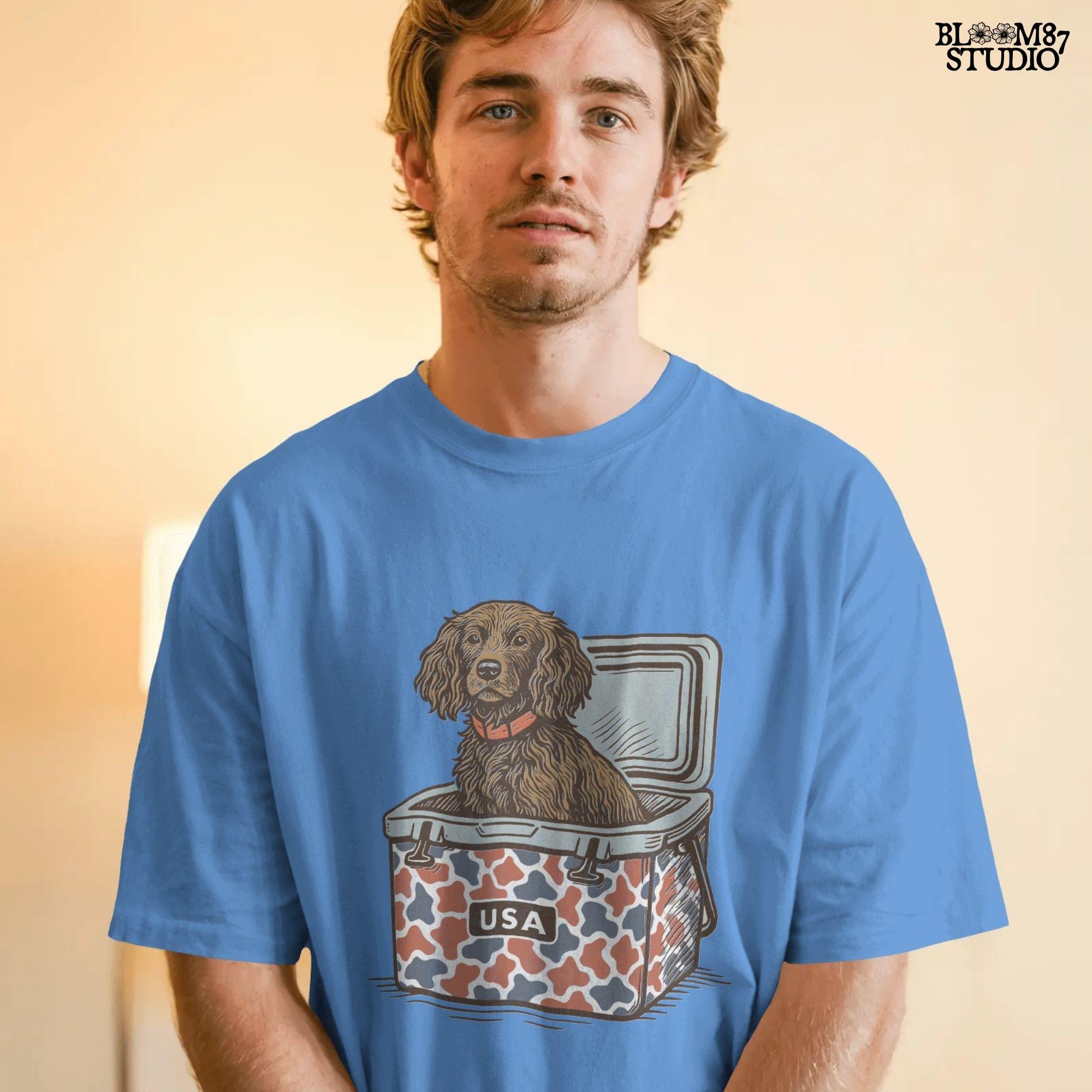 Sporting dog (spaniel type) sitting in a patriotic red-white-blue camo cooler labeled “USA” – sublimation PNG for southern dog lovers and summer crafts.