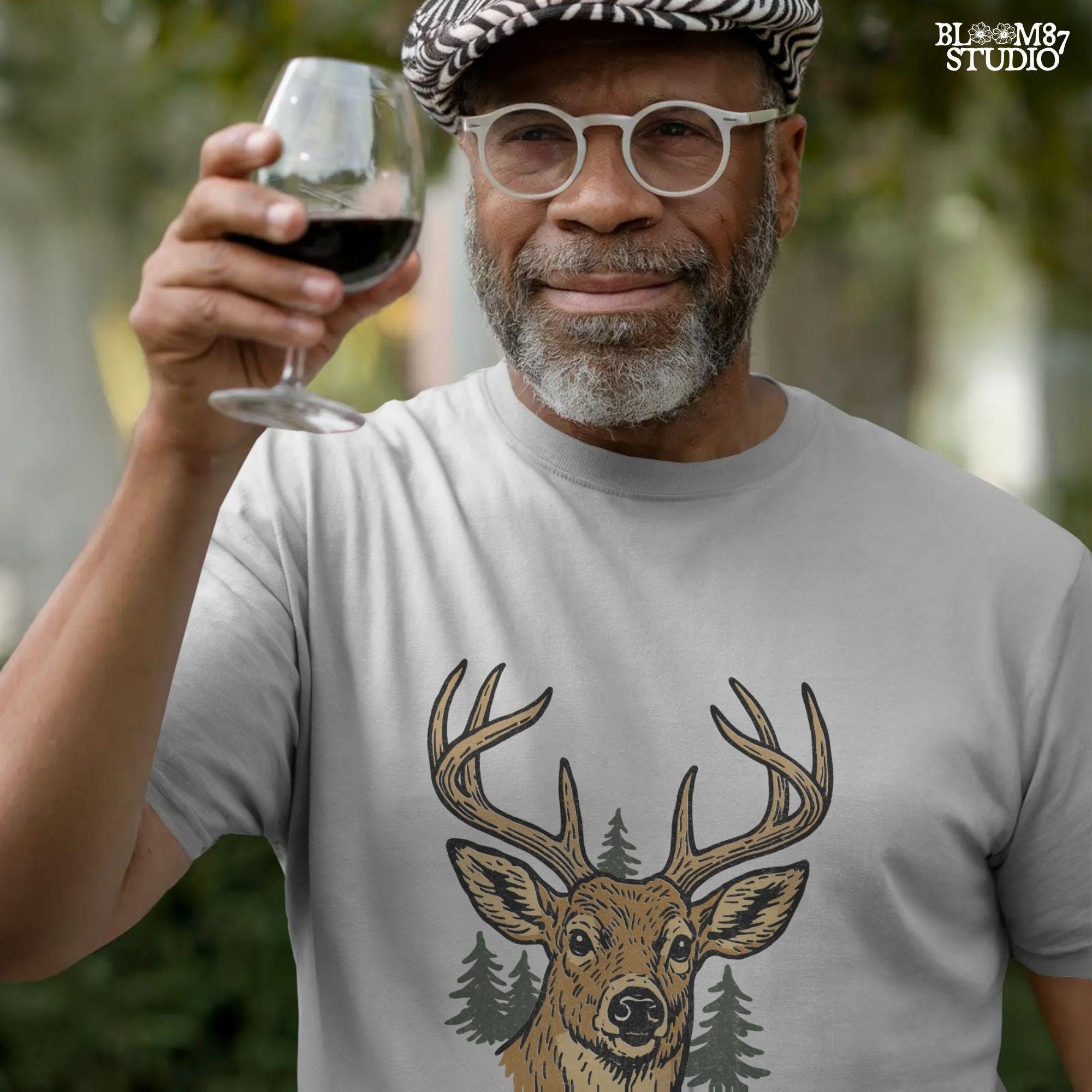 Rustic illustration of a buck deer with antlers and pine trees, text below says “Best Buckin’ Dad Ever” in bold and script font