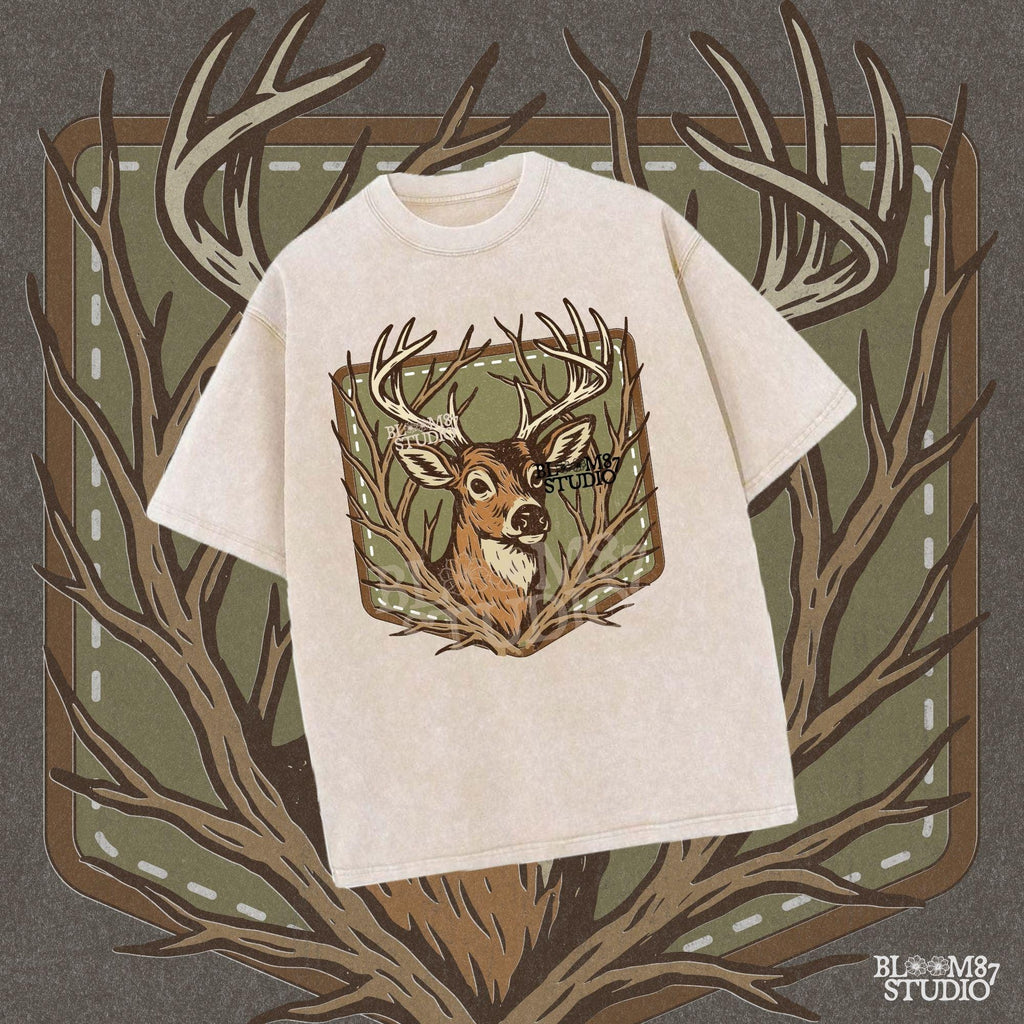 Stylized deer head with antlers framed by bare branches, placed on an olive green patch background with stitching detail.