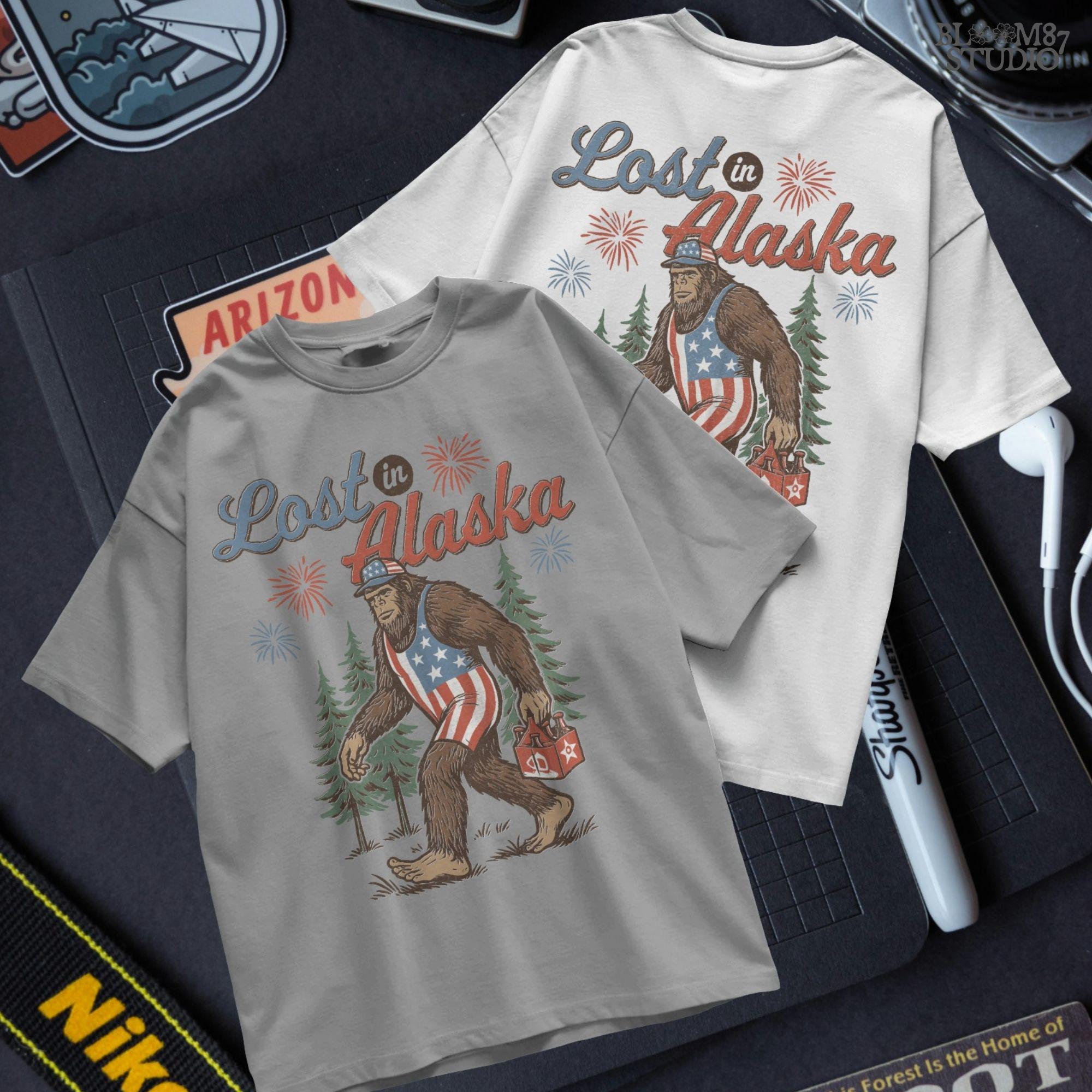 Bigfoot wearing an American flag outfit and cap, walking through forest with fireworks in background, holding a six-pack of beer with “Lost in Alaska” text