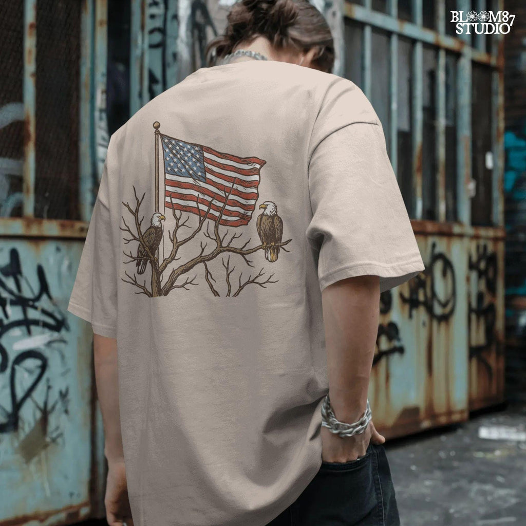 Two bald eagles perched on leafless tree branches in front of a waving American flag in a vintage-style illustration.