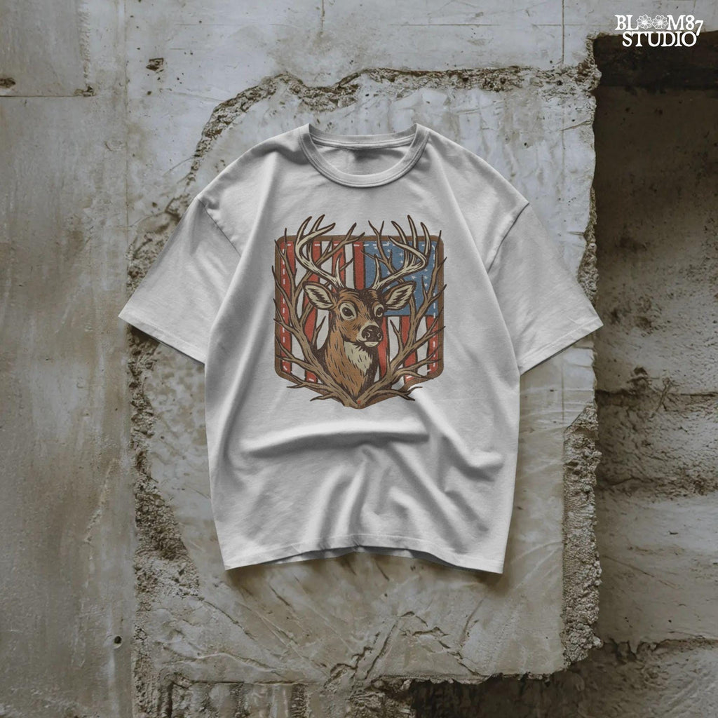 Illustration of a proud buck with large antlers standing in front of a stitched American flag patch, rustic hunting style.