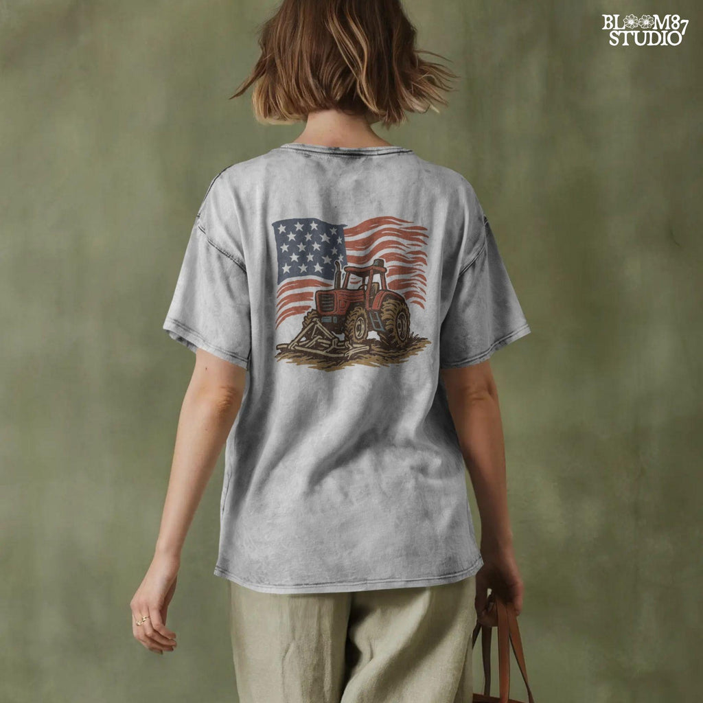 Red tractor with plow on soil, American flag waving in the background, vintage farm-themed graphic.