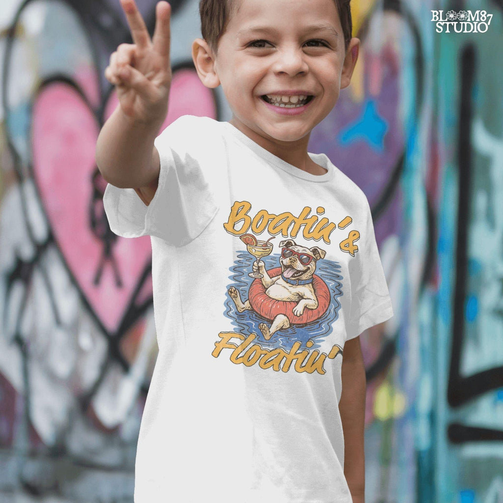 Cartoon bulldog in red sunglasses floating on a tube, holding a margarita, with “Boatin’ & Floatin’” summer text.