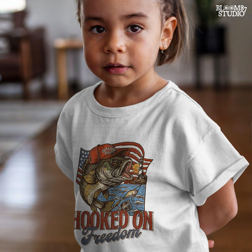 Patriotic bass fish wearing red cap with American flag, lighthouse, and “Hooked on Freedom” text – ideal for 4th of July fishing designs.