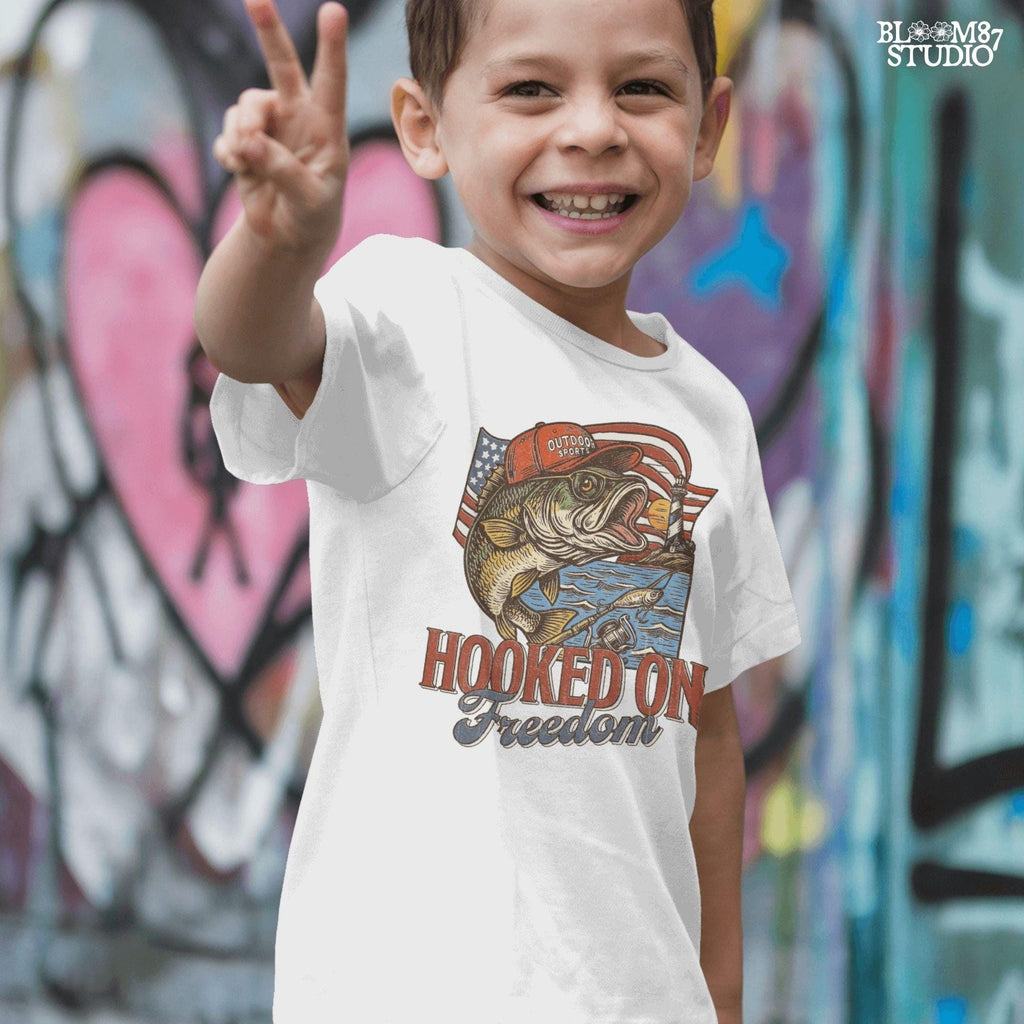Patriotic bass fish wearing red cap with American flag, lighthouse, and “Hooked on Freedom” text – ideal for 4th of July fishing designs.