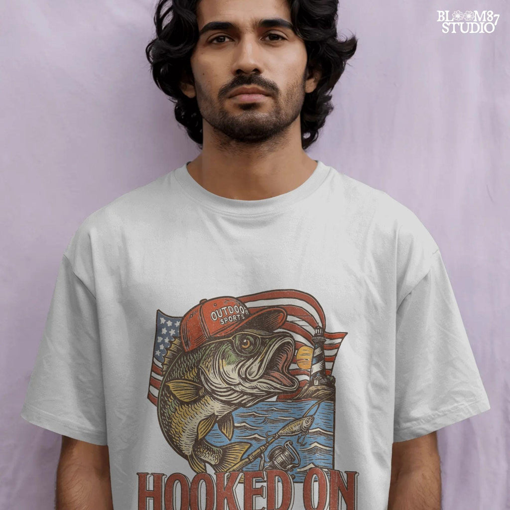 Patriotic bass fish wearing red cap with American flag, lighthouse, and “Hooked on Freedom” text – ideal for 4th of July fishing designs.