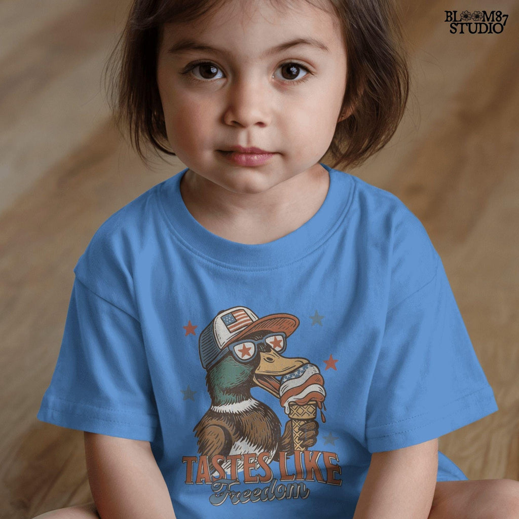 Funny cartoon duck wearing USA hat and star sunglasses, licking patriotic ice cream cone with “Tastes Like Freedom” text and red-white-blue stars