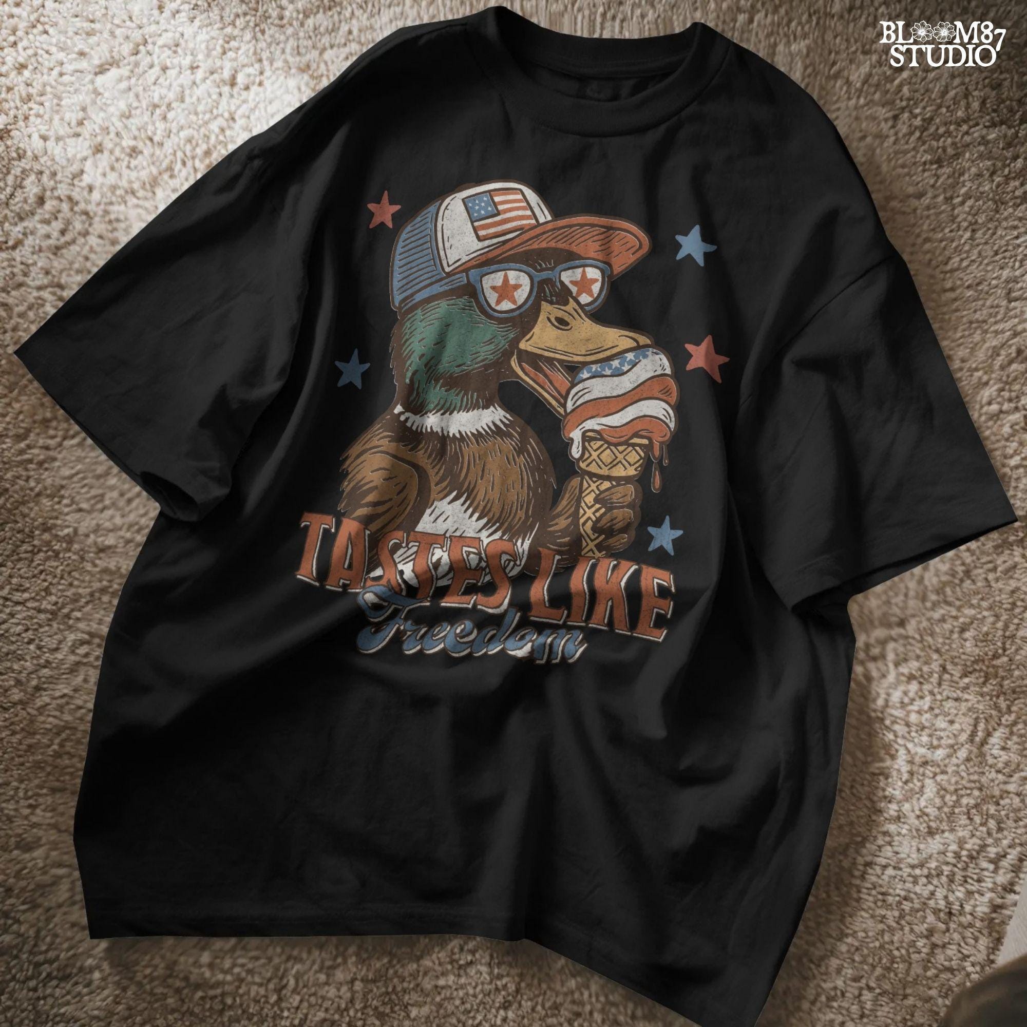 Funny cartoon duck wearing USA hat and star sunglasses, licking patriotic ice cream cone with “Tastes Like Freedom” text and red-white-blue stars