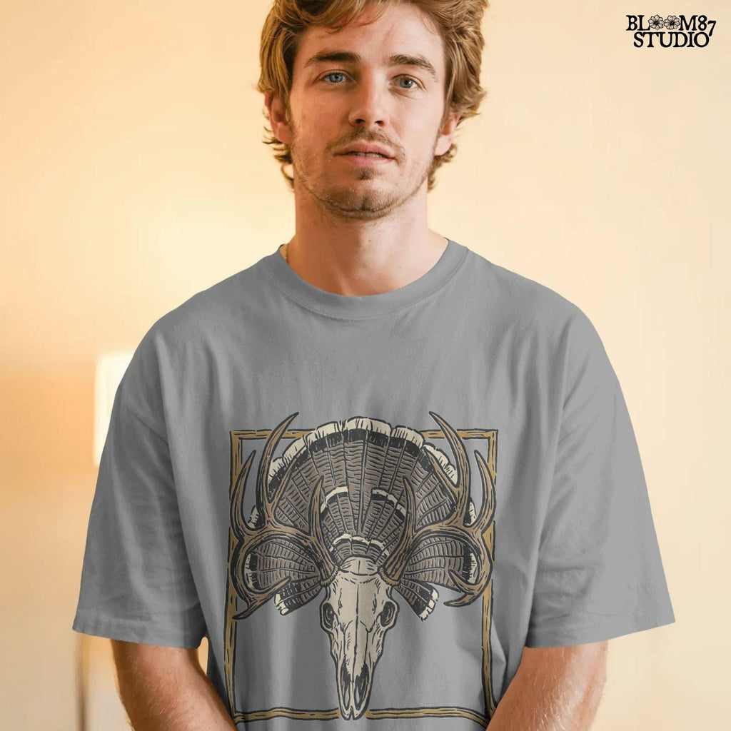 Illustration of a deer skull with antlers set in front of a fanned turkey tail and framed in a rustic square border