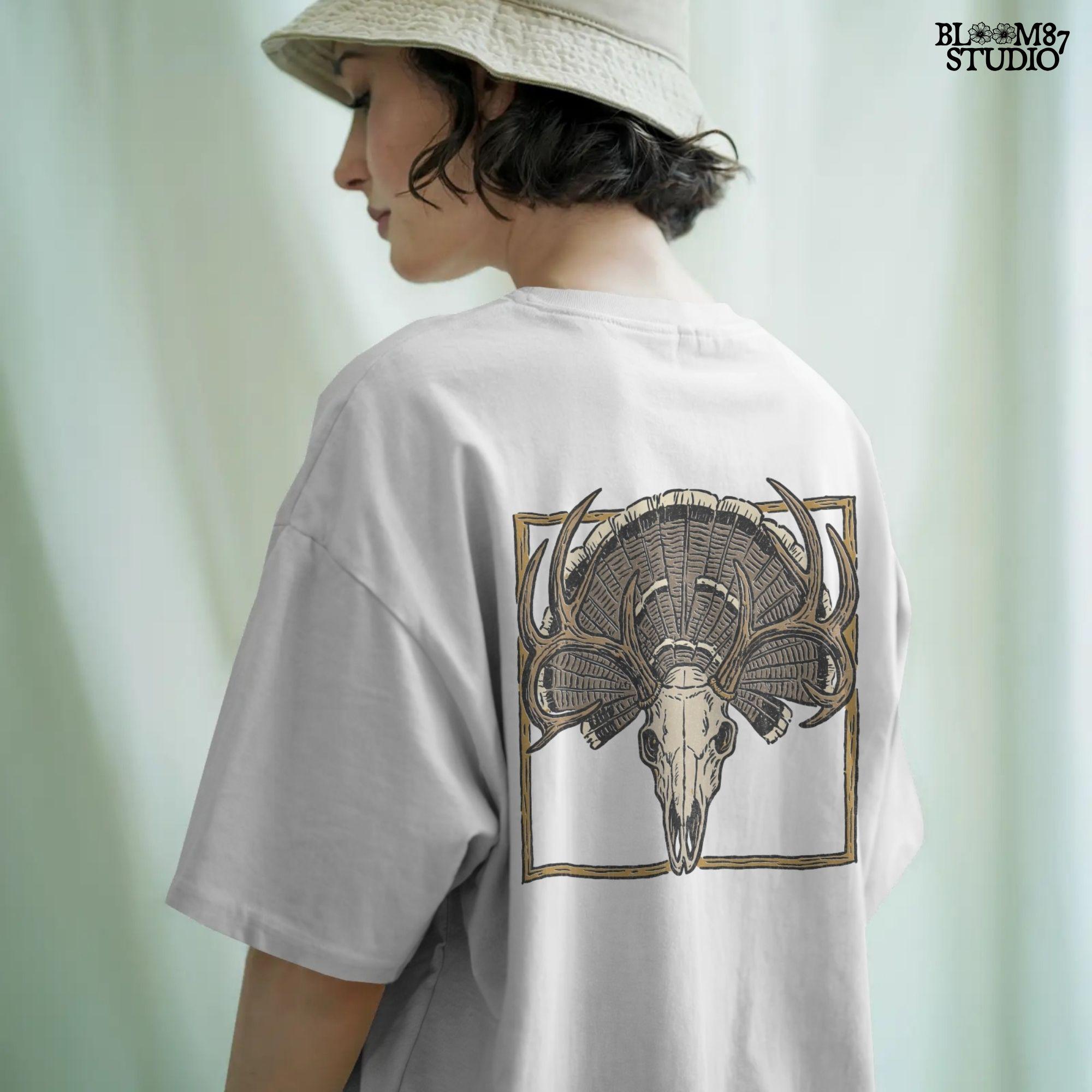 Illustration of a deer skull with antlers set in front of a fanned turkey tail and framed in a rustic square border