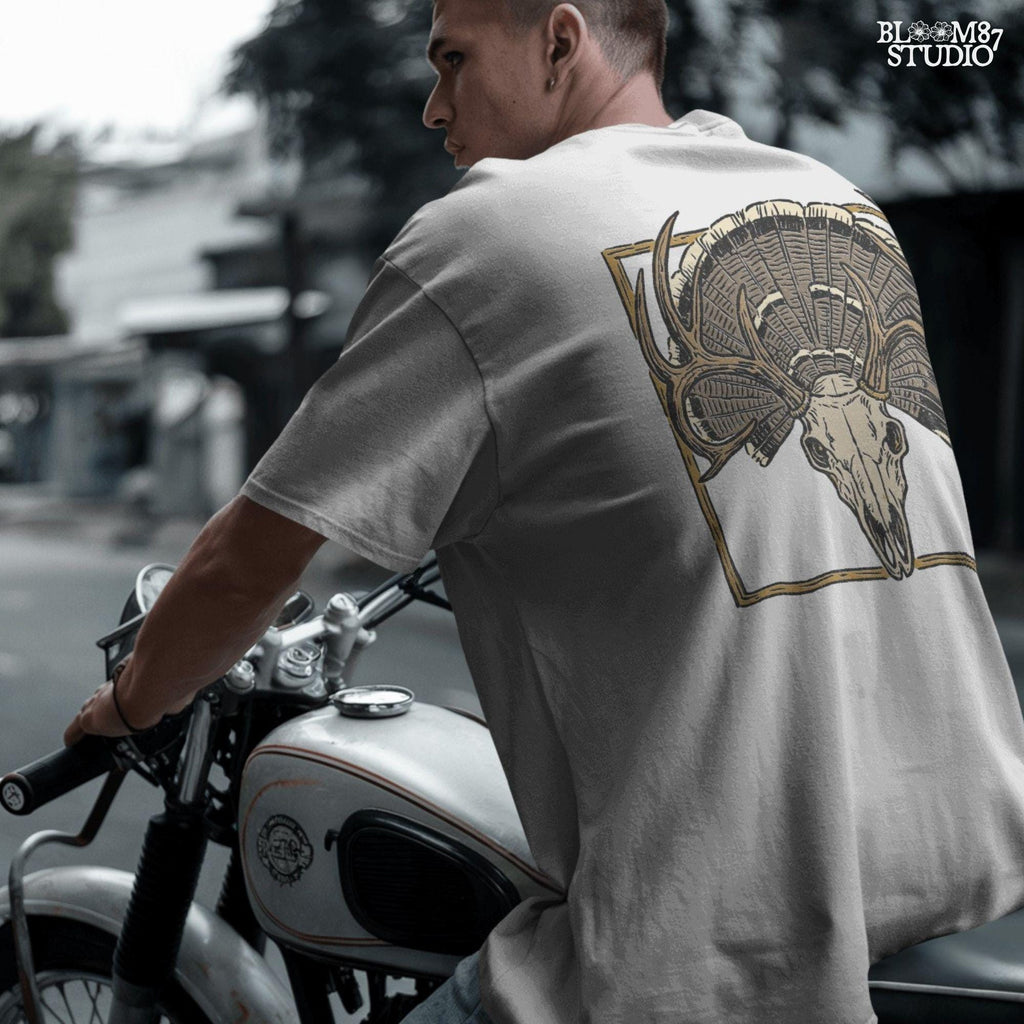 Illustration of a deer skull with antlers set in front of a fanned turkey tail and framed in a rustic square border