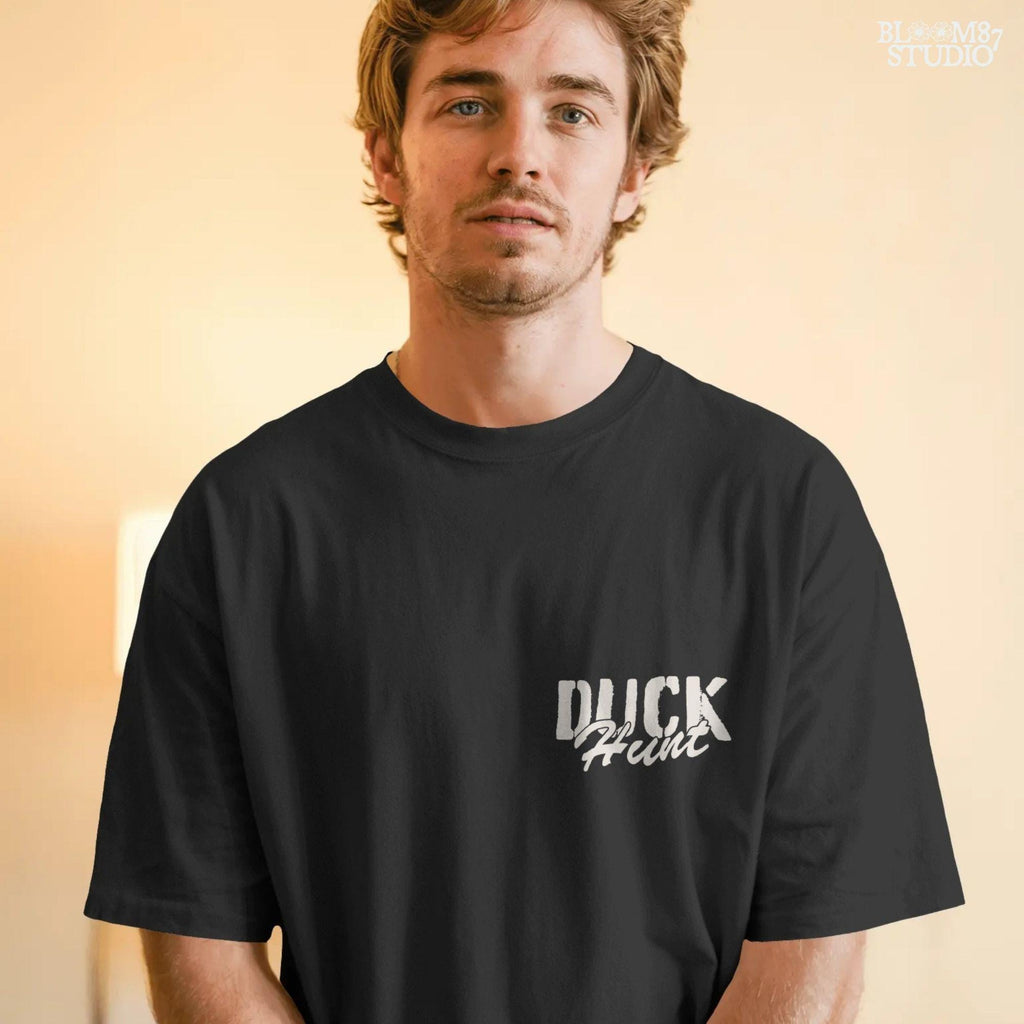 Rustic illustration of a duck hunter with shotgun standing beside his dog in a marsh, watching ducks fly overhead under a blue sky