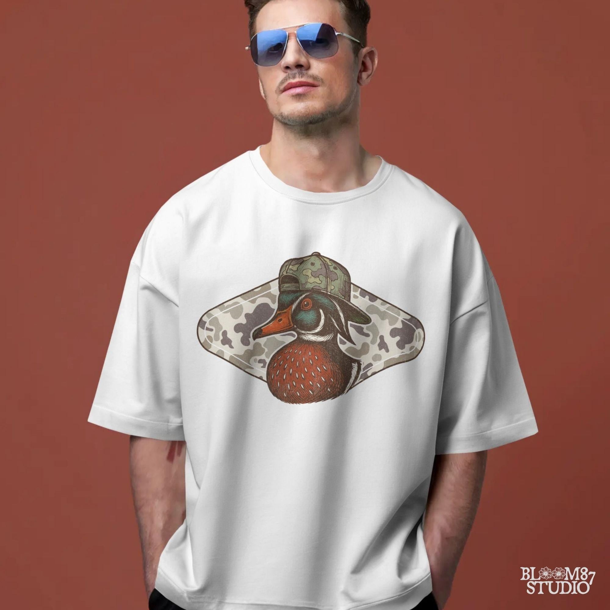 Funny wood duck wearing camo hat in front of marsh camo background – southern hunting sublimation design.