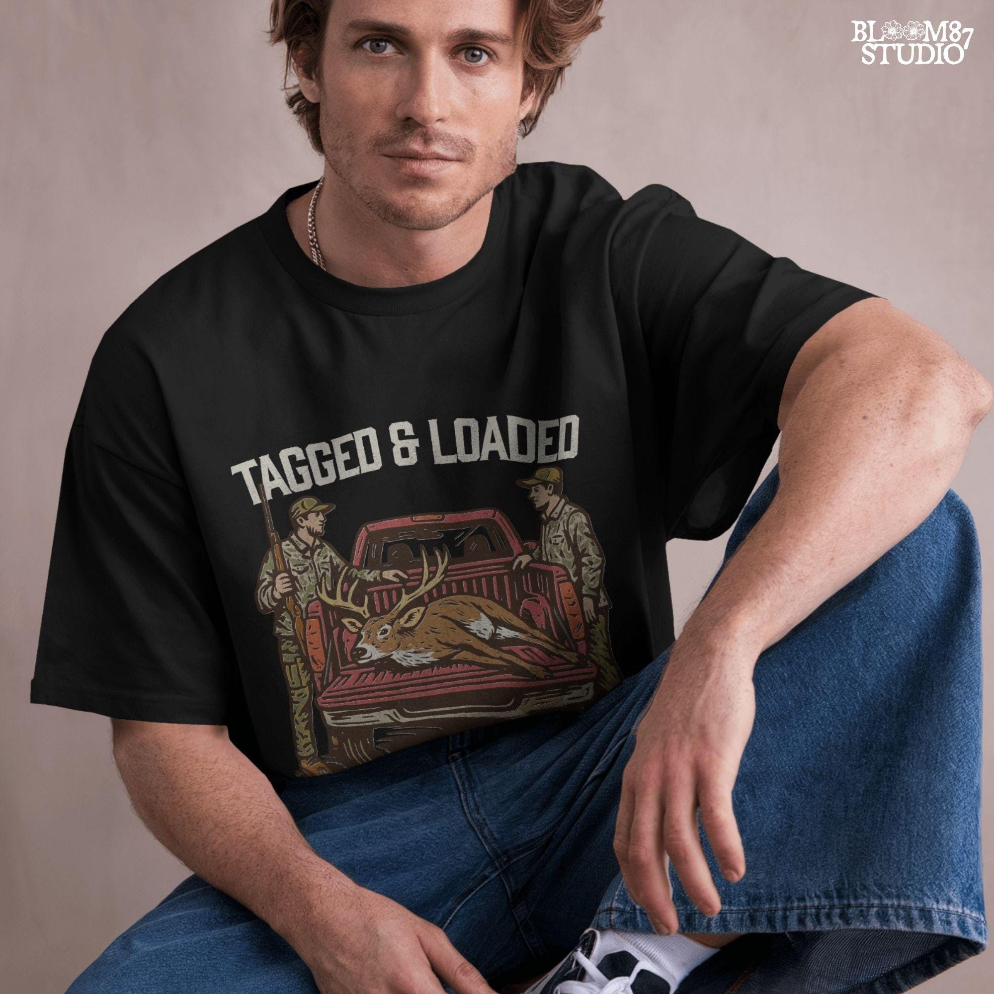 Rustic hunting design with two hunters, a truck, and a buck in the bed. Tagged and Loaded quote for deer season and outdoor graphics.