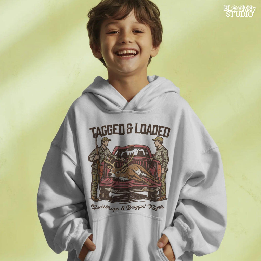 Rustic hunting design with two hunters, a truck, and a buck in the bed. Tagged and Loaded quote for deer season and outdoor graphics.