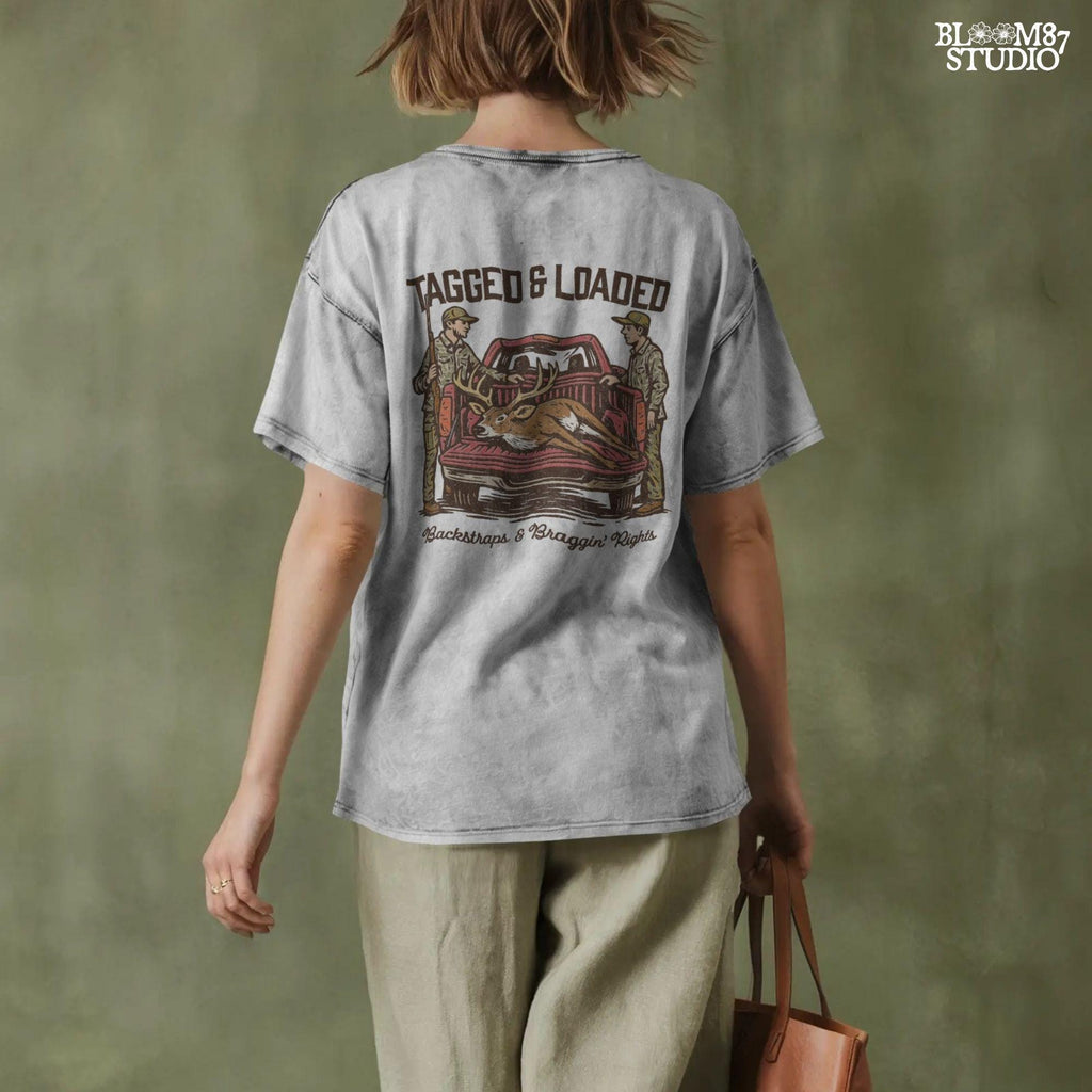 Rustic hunting design with two hunters, a truck, and a buck in the bed. Tagged and Loaded quote for deer season and outdoor graphics.