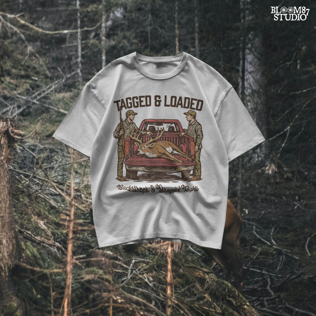Rustic hunting design with two hunters, a truck, and a buck in the bed. Tagged and Loaded quote for deer season and outdoor graphics.
