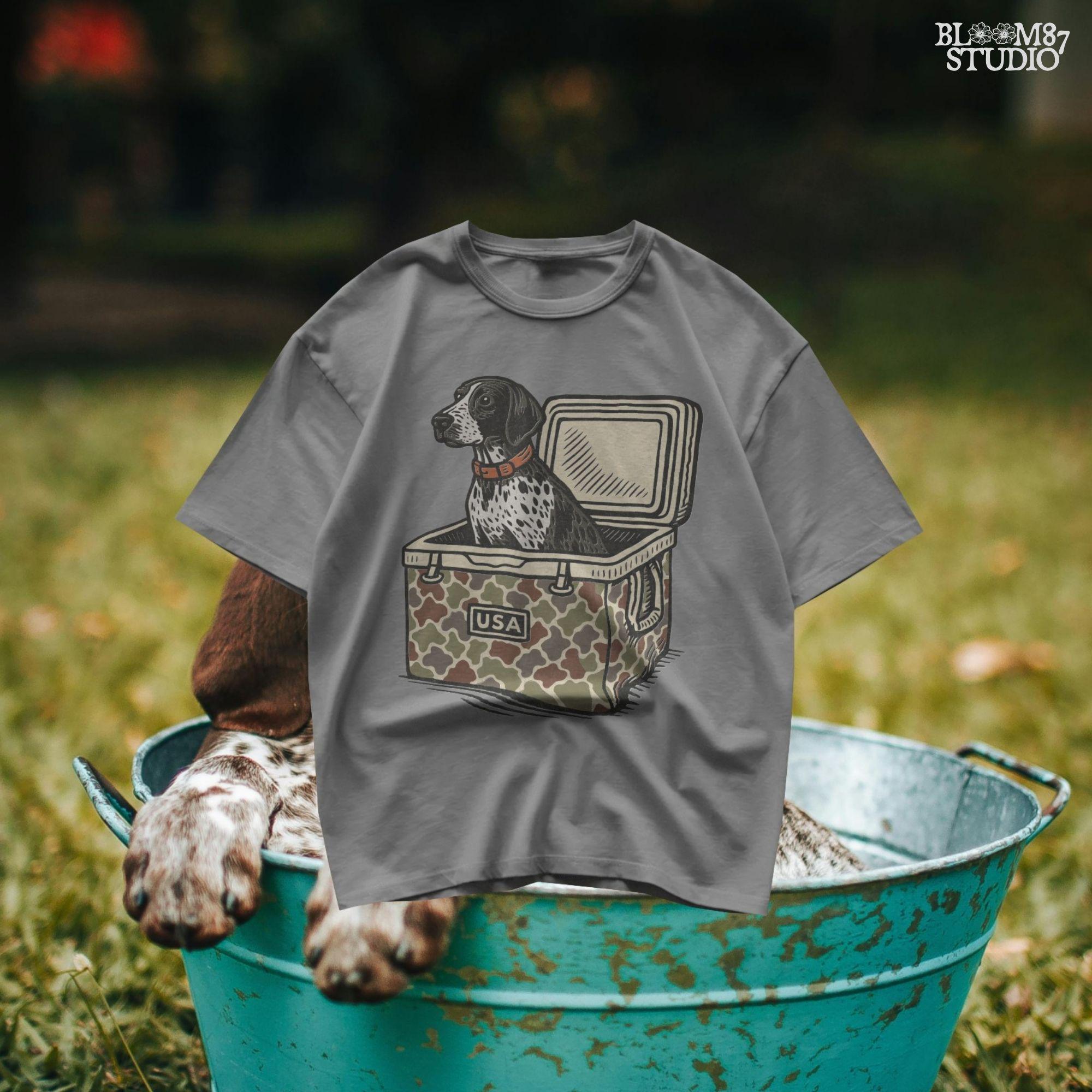 German Shorthaired Pointer dog sitting inside camouflage cooler labeled “USA,” in rustic cartoon patriotic style