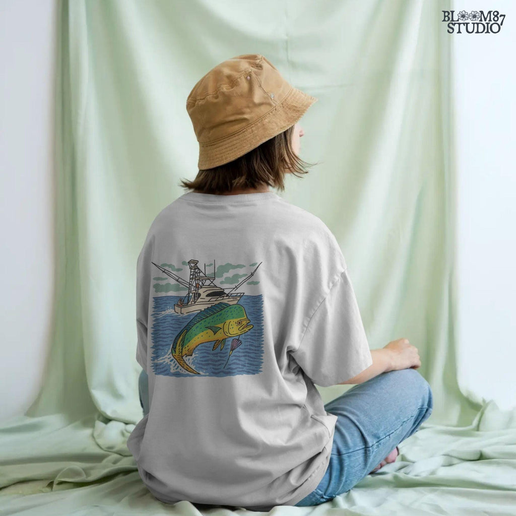 Colorful hand-drawn illustration of a mahi-mahi fish jumping in front of a sport fishing boat on the ocean, designed for sublimation and fishing-themed products.