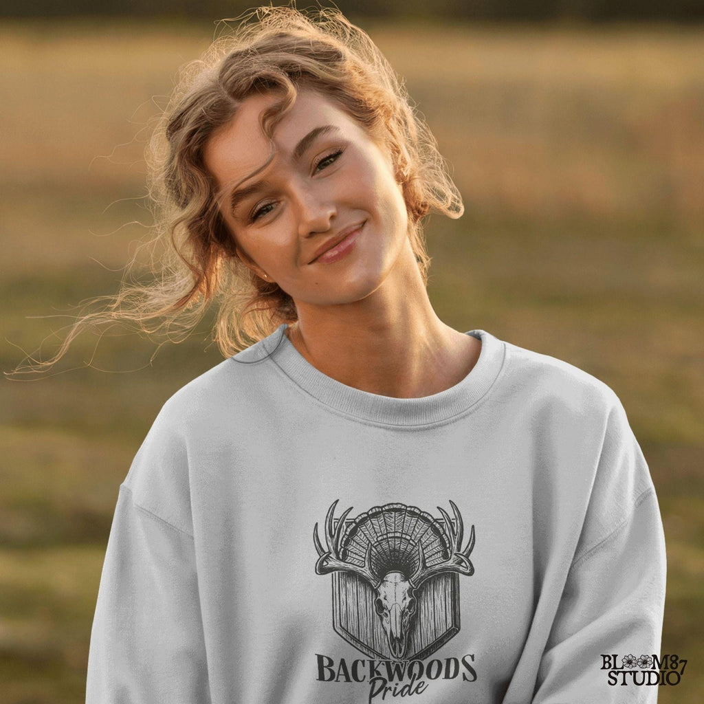 Rustic design of a deer skull with antlers and a turkey fan backdrop above the words “Backwoods Pride,” perfect for country and hunting themes.