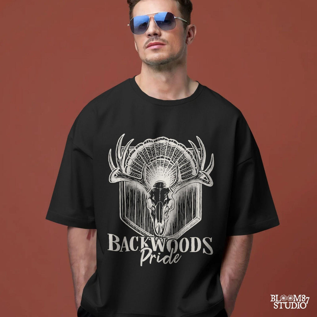 Rustic design of a deer skull with antlers and a turkey fan backdrop above the words “Backwoods Pride,” perfect for country and hunting themes.