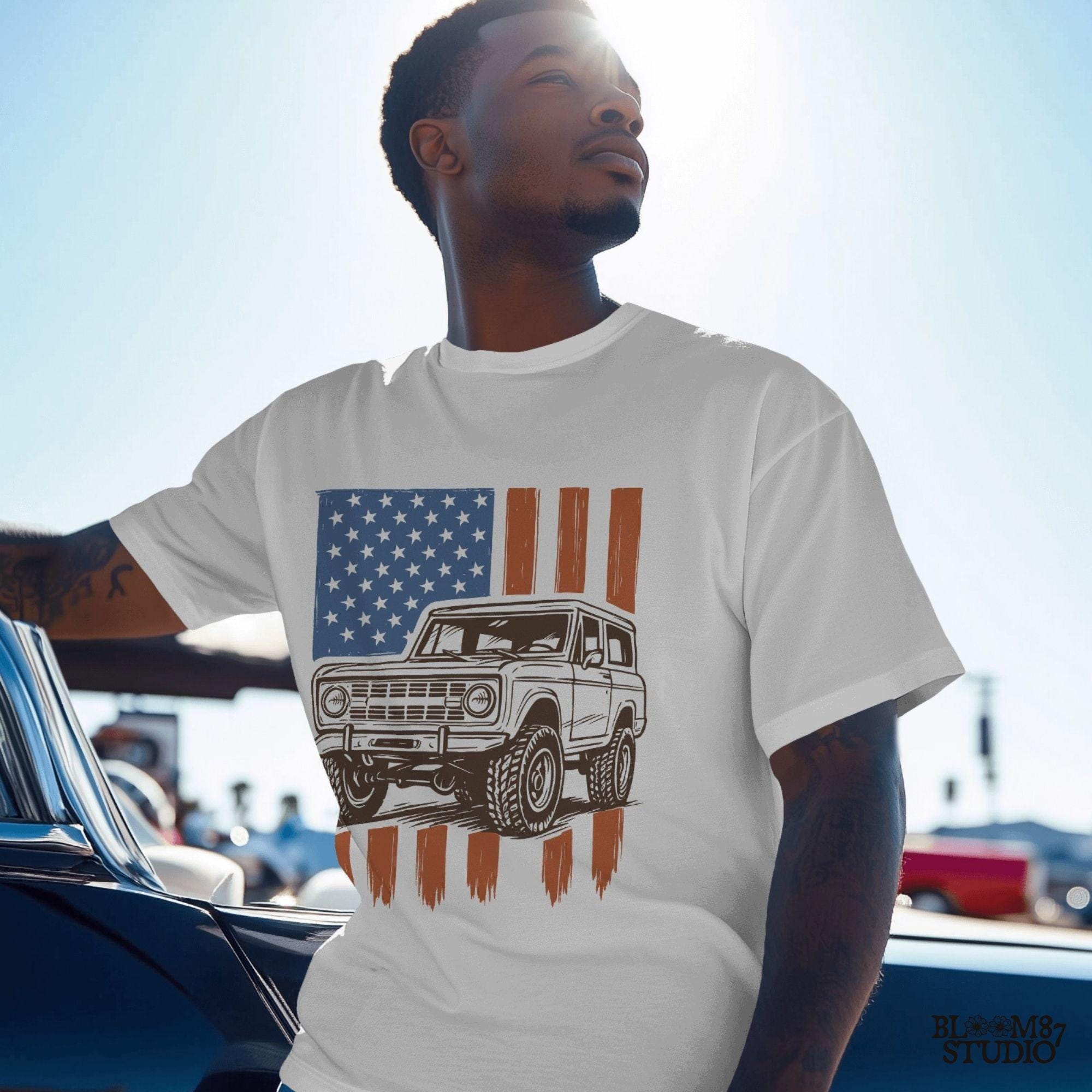 Vintage 4x4 Bronco-style off-road truck with bold tires over a distressed American flag, perfect for patriotic truck lovers and USA-themed designs.