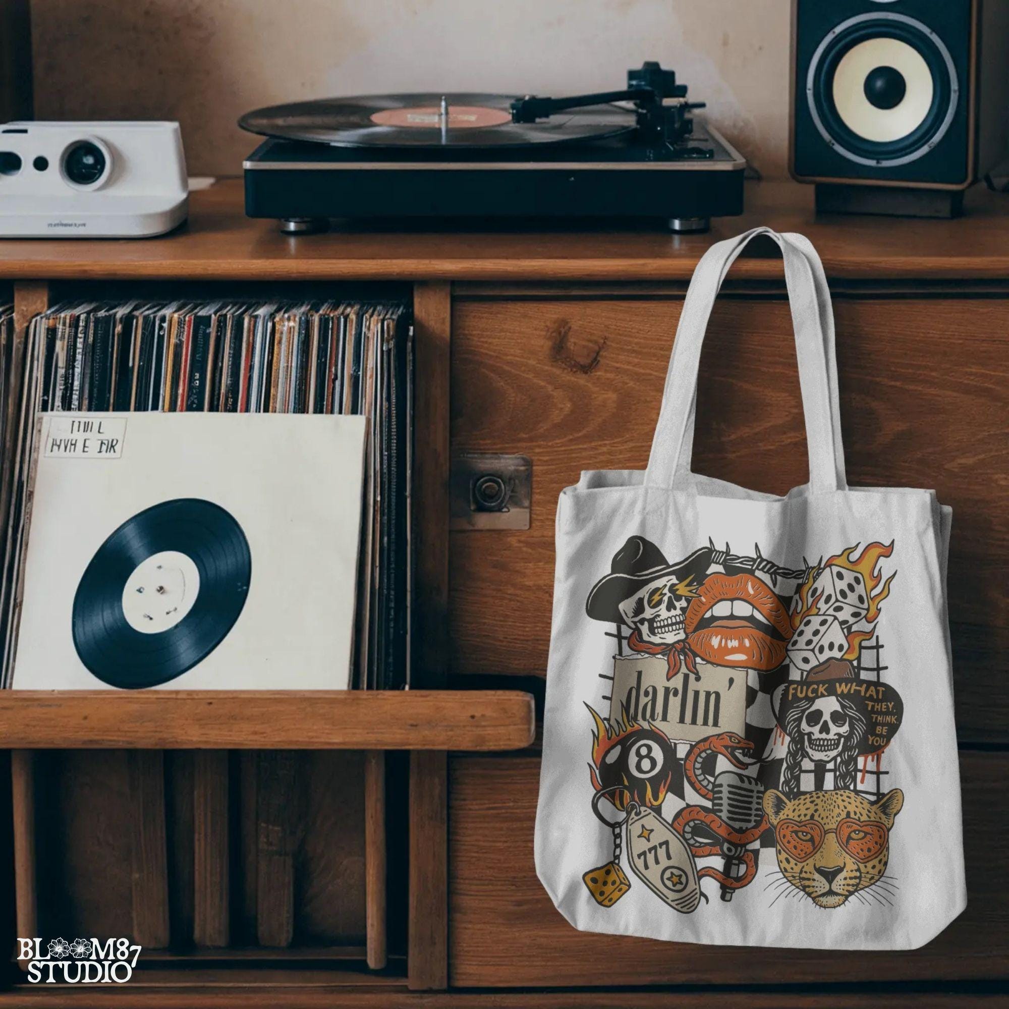 Western punk collage design featuring skulls, lips, leopard with heart glasses, snake and microphone, dice, barbed wire, and 777 tag.