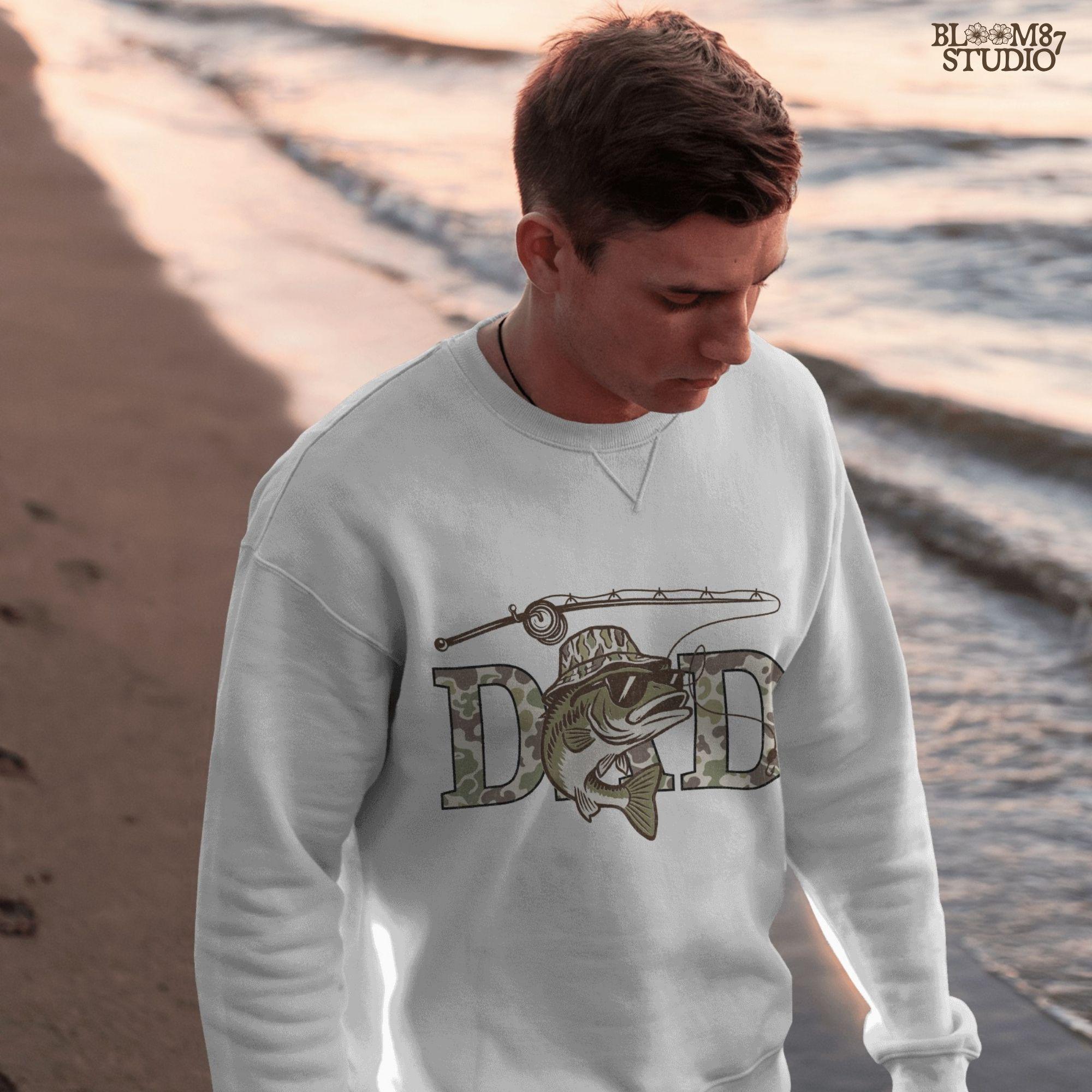 A funny camo bass fish wearing sunglasses and a camo bucket hat, with large camouflage DAD lettering and a fishing pole above.