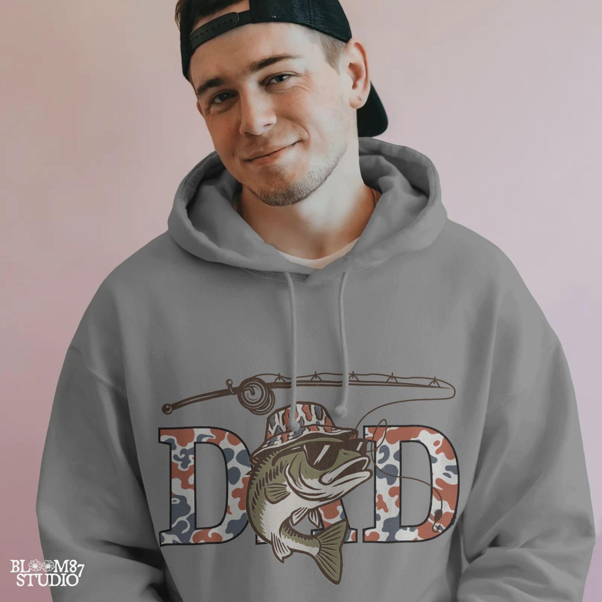 A cool bass fish wearing sunglasses and a bucket hat over red white and blue camo letters spelling DAD, with a fishing rod above.