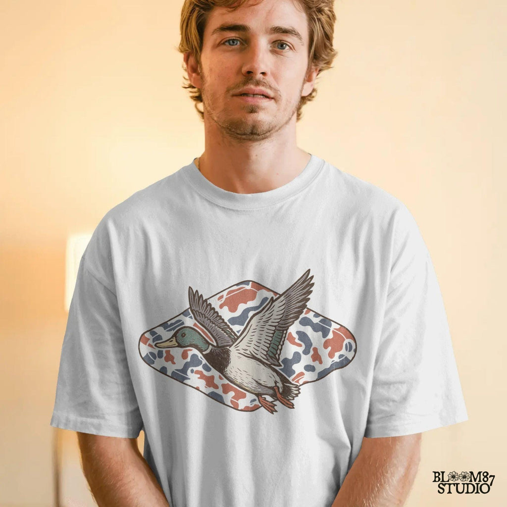 Mallard duck flying over a red, white, and blue camo background, patriotic hunting-themed PNG graphic for 4th of July projects.