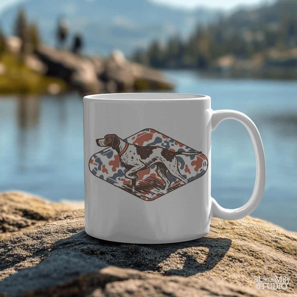 Patriotic illustration of a pointing hunting dog in red, white, and blue camo background, perfect for upland hunting fans and 4th of July projects.