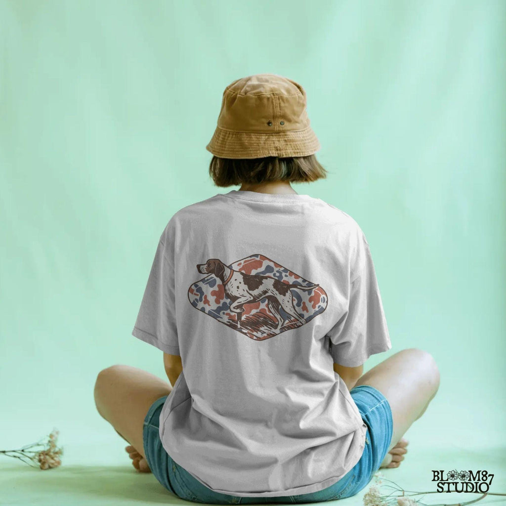 Patriotic illustration of a pointing hunting dog in red, white, and blue camo background, perfect for upland hunting fans and 4th of July projects.