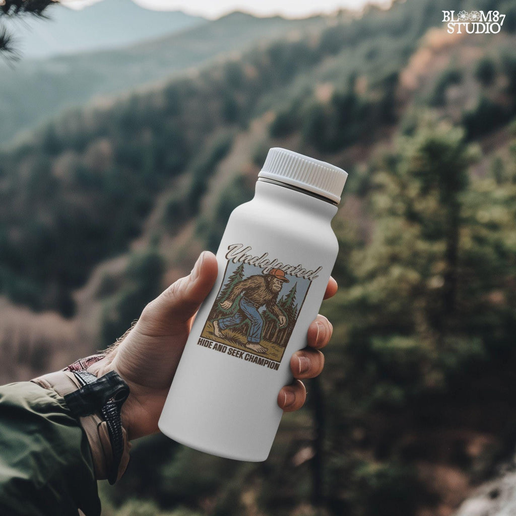 Hand-drawn Bigfoot walking through a pine forest in a red cap and jeans, with text “Undefeated Hide and Seek Champion,” designed for sublimation use.